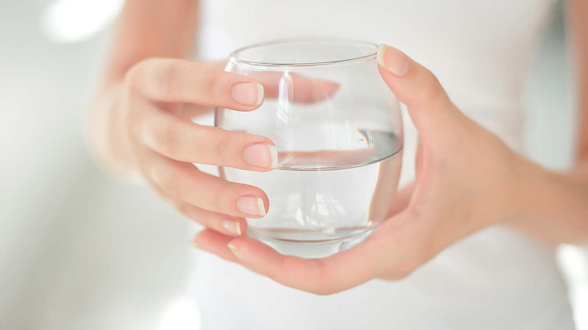 Viel trinken ist gesund: Frau hält ein Glas mit Wasser