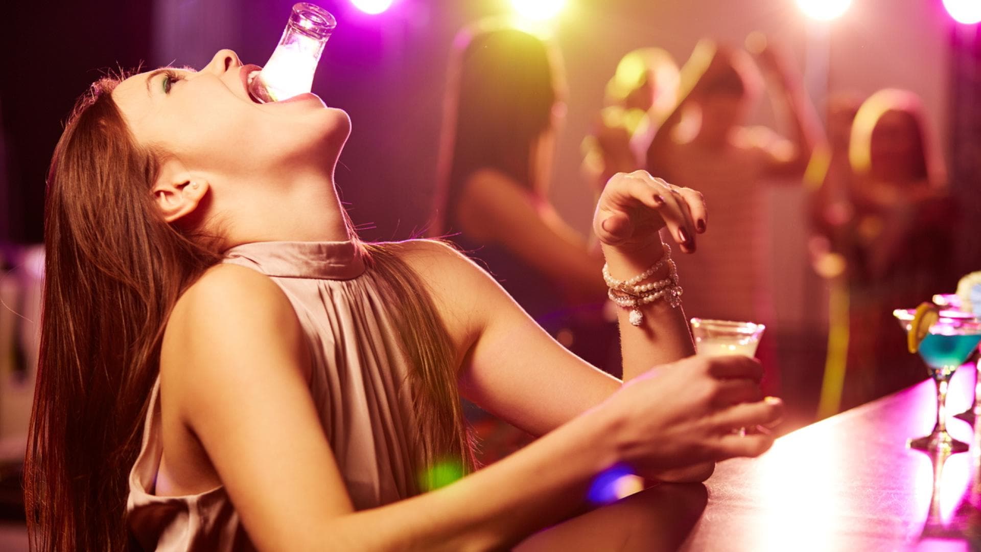 Frau in der Bar trinkt Shots