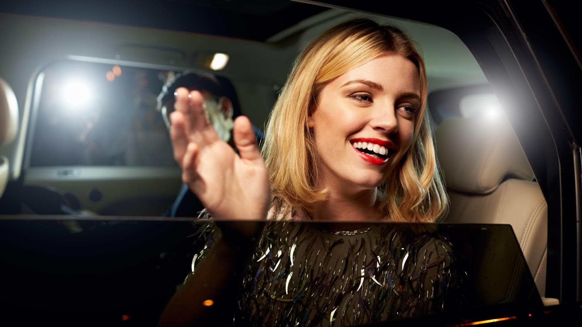 Berühmte Frau winkt aus Auto