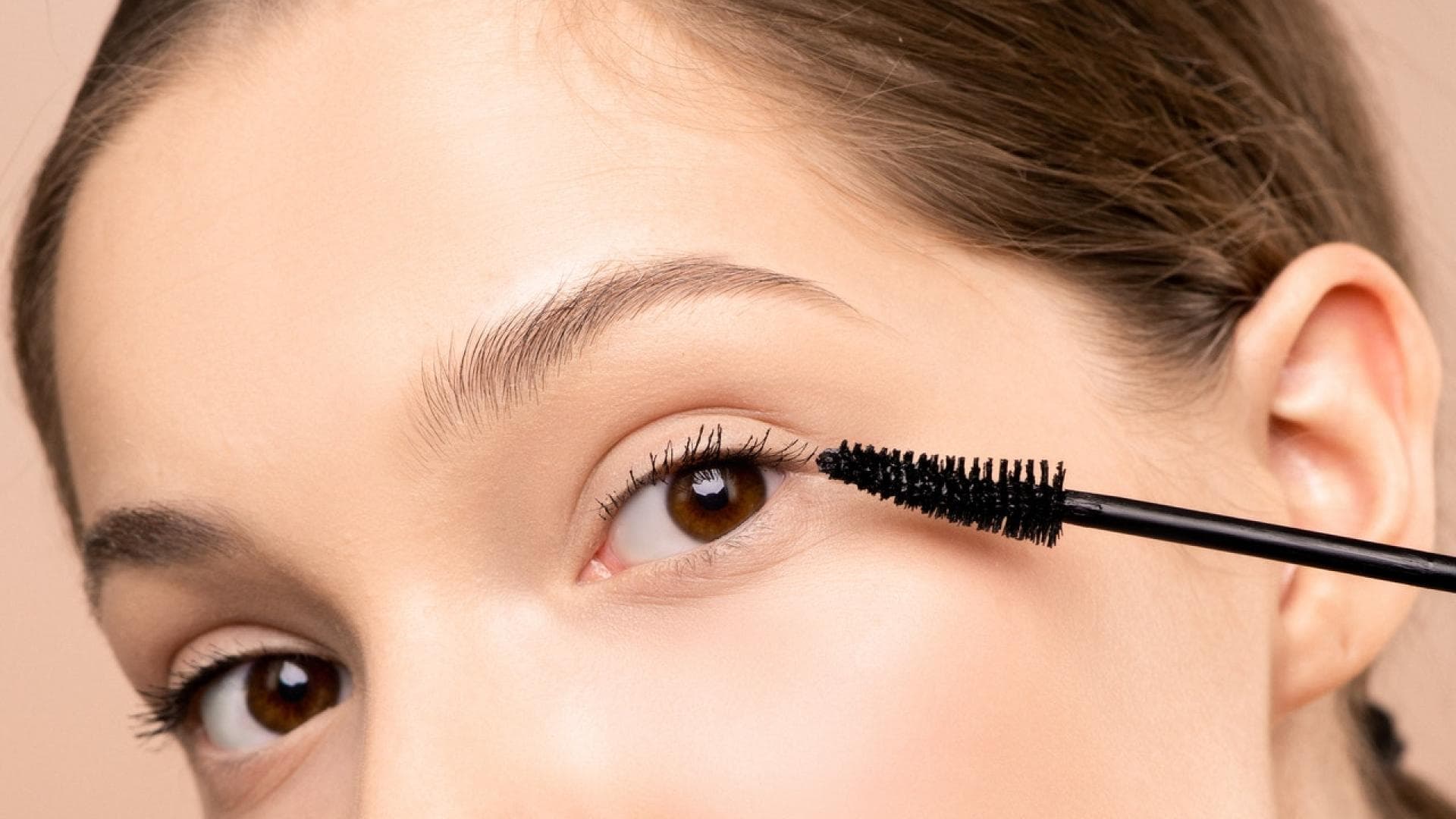 Frau tuscht Wimpern
