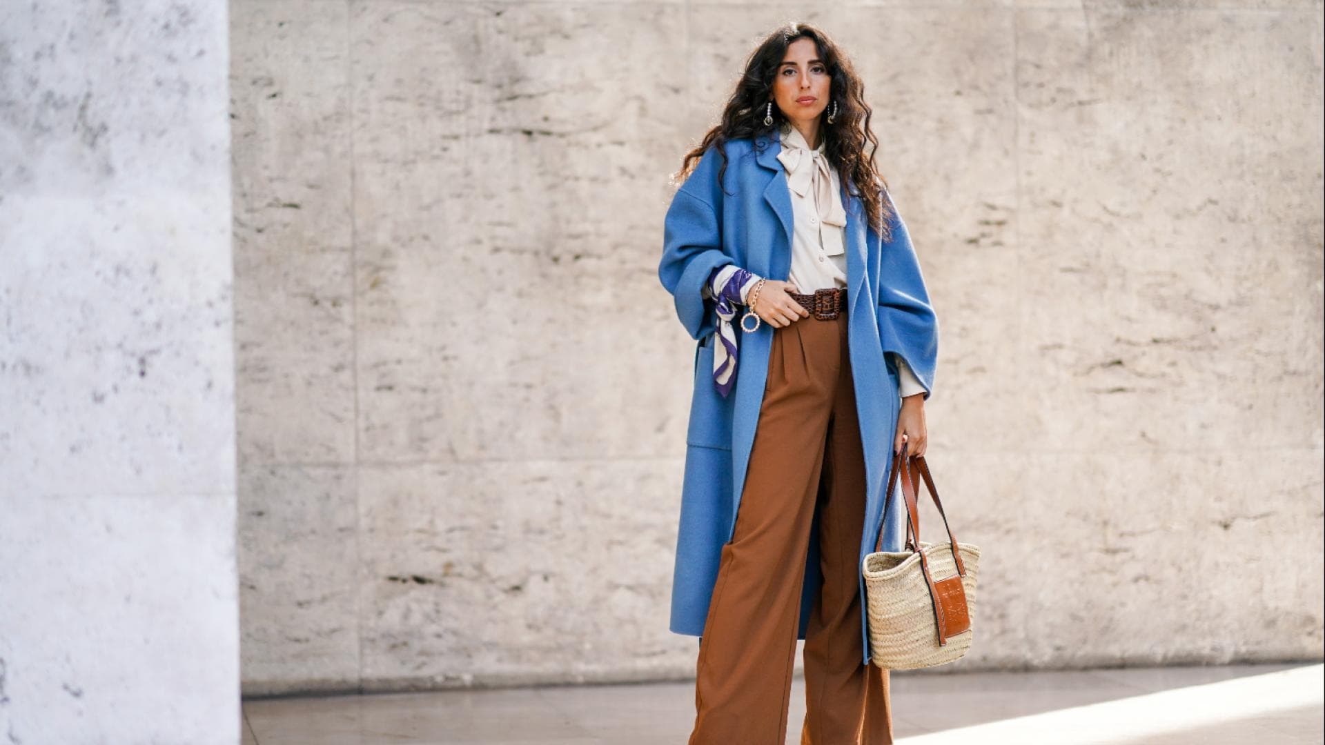 Frau in weiter Hose und blauem Mantel