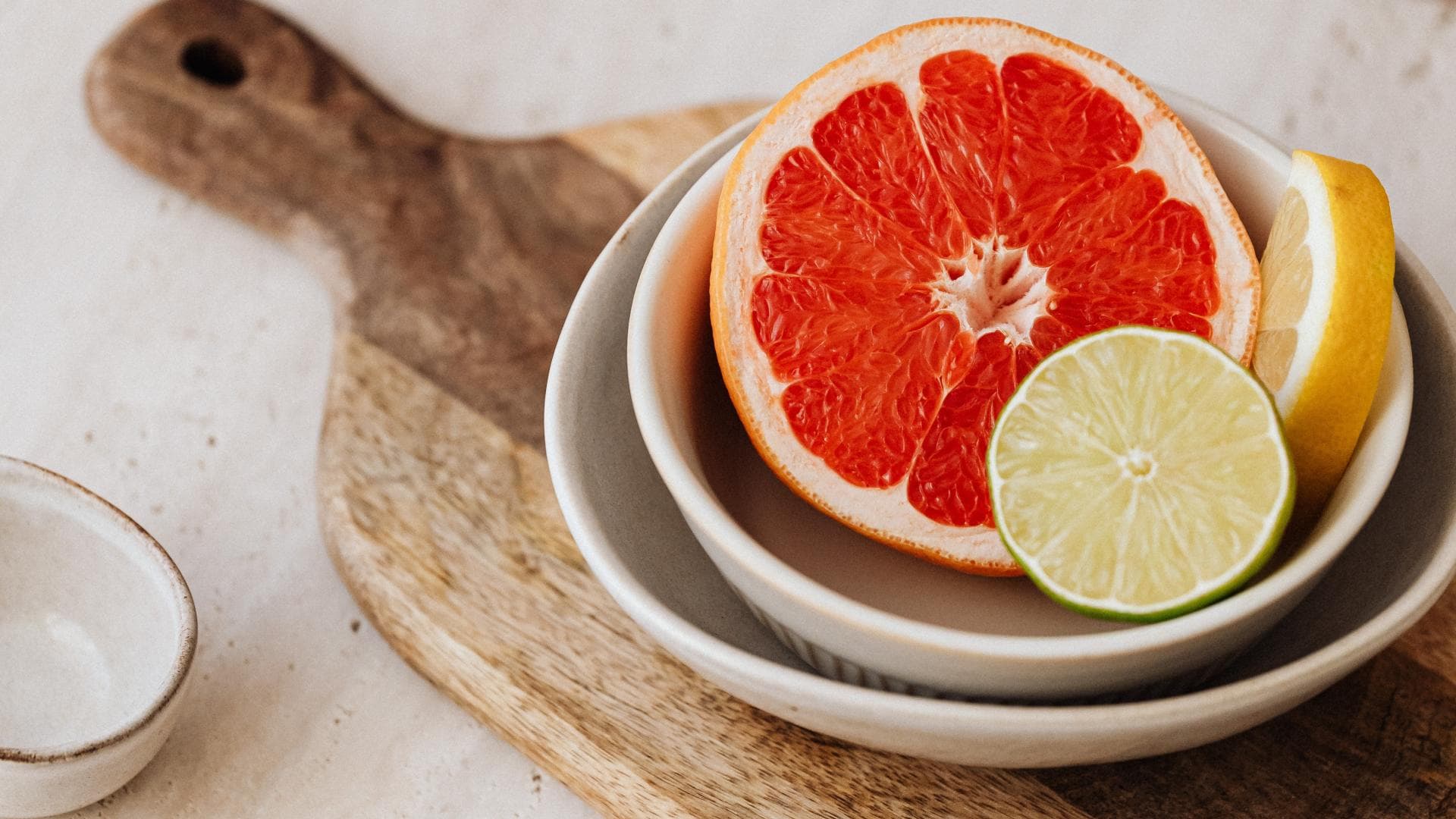 Eine halbe Grapefruit liegt auf einem Schneidebrett.