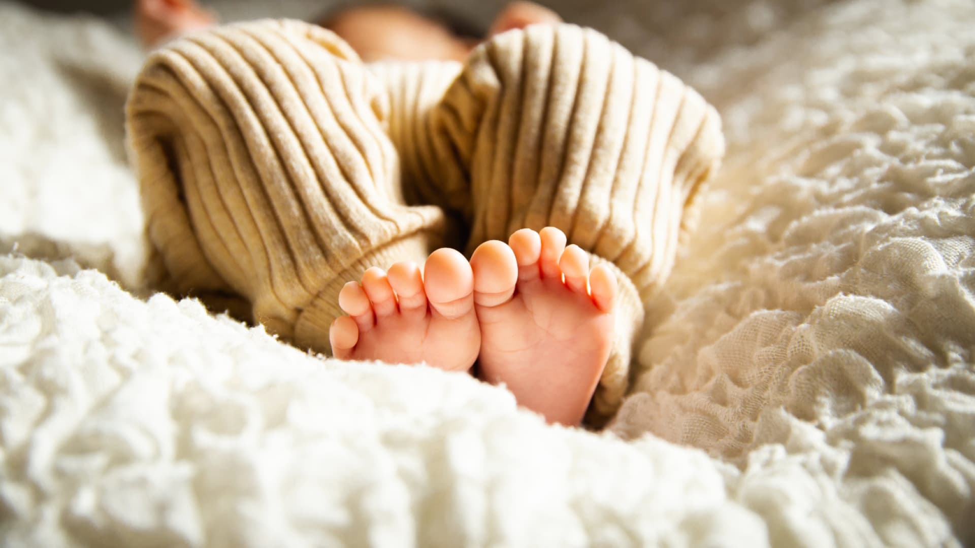 Baby liegt auf dem Bett