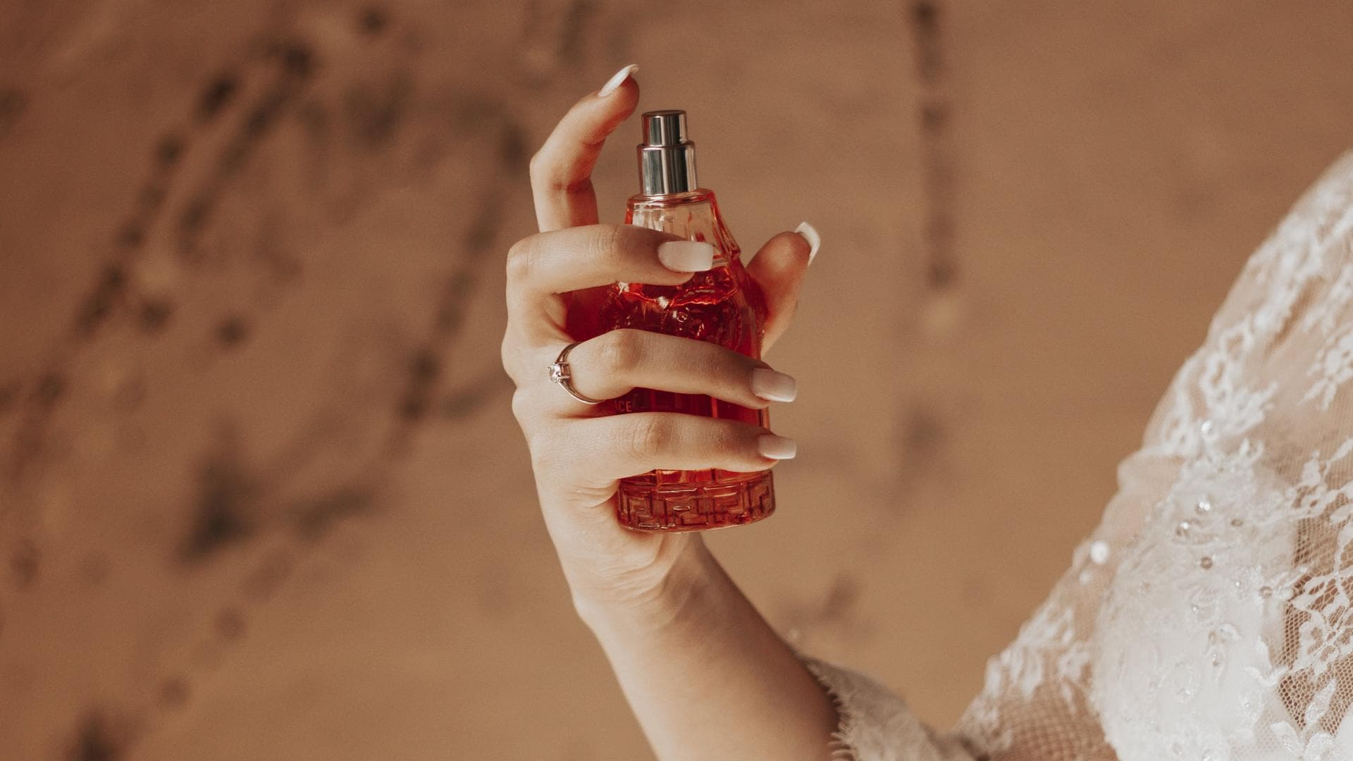 Frau trägt Parfum mit Amber auf.
