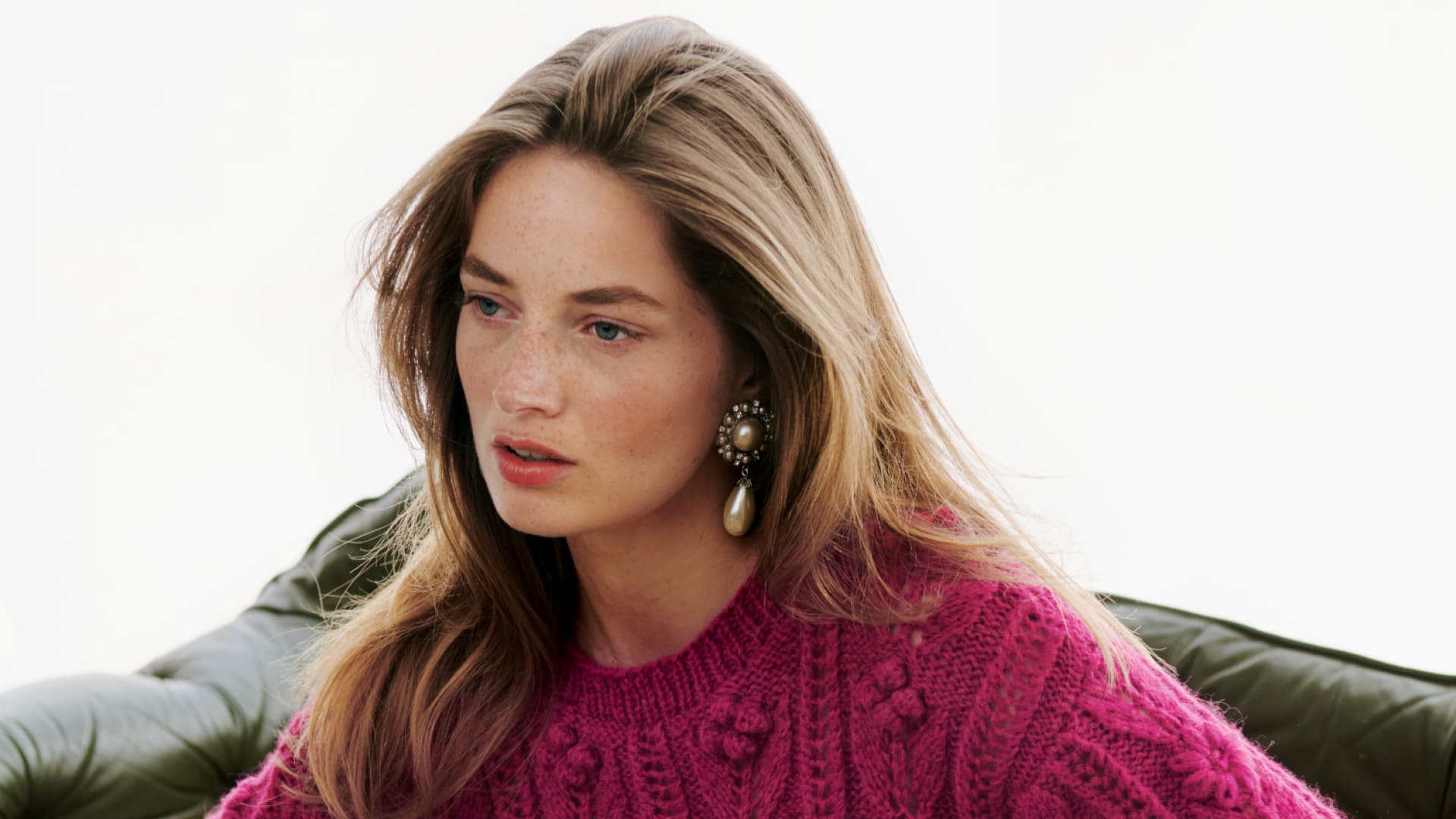 Frau in pinkem Zopfstrickpullover