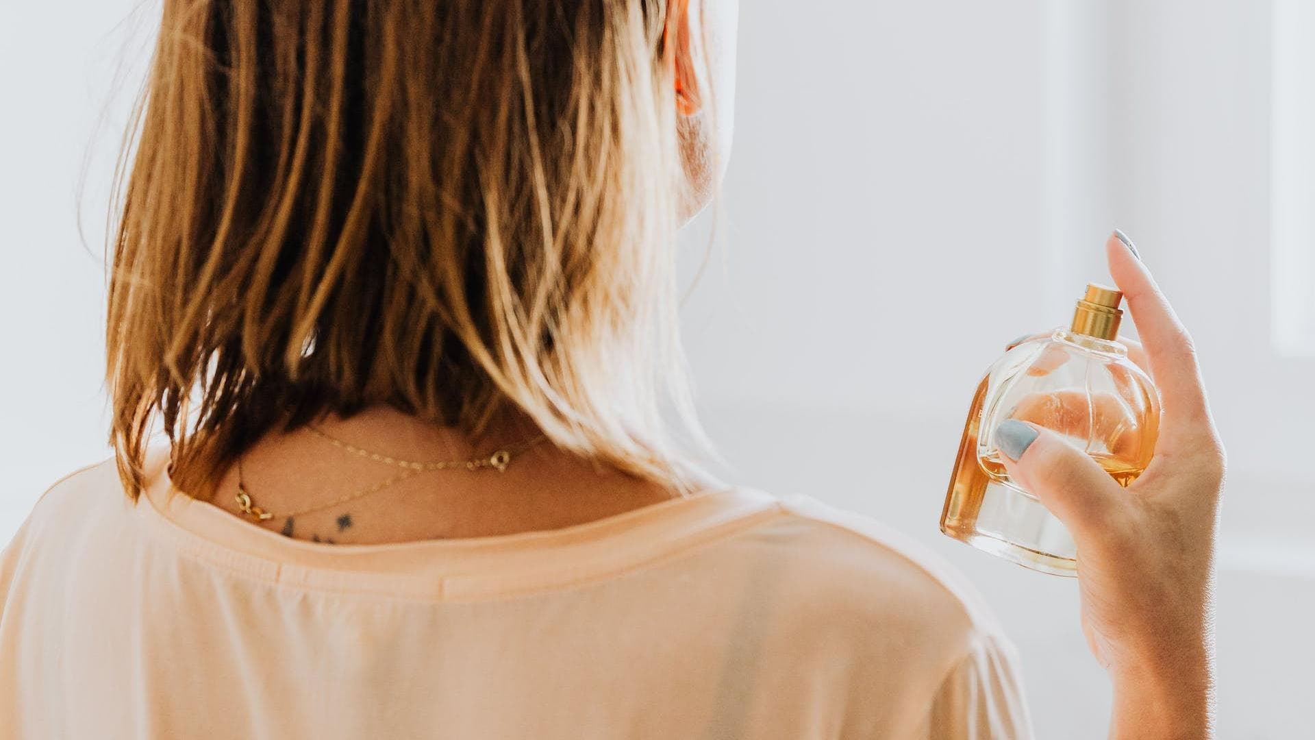 Frau sprüht Parfum wie frische Wäsche