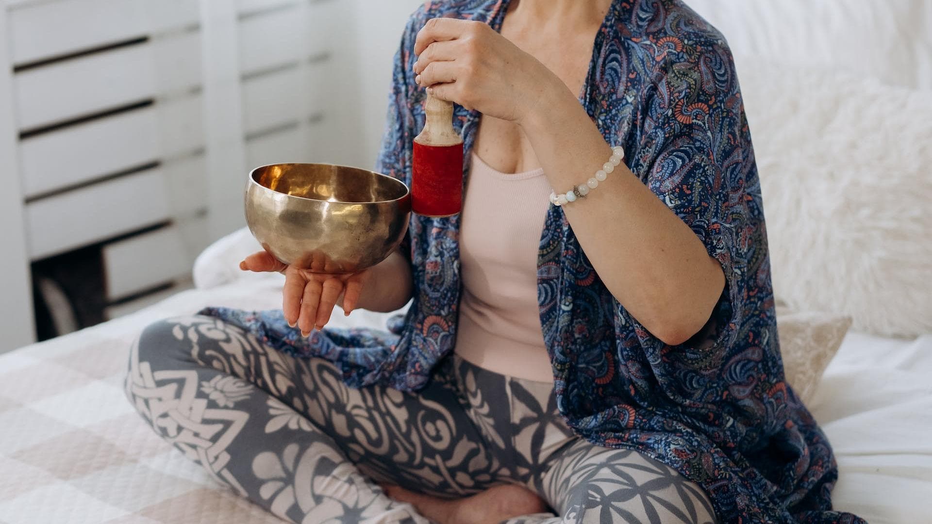 Eine Frau macht ein ayurvedisches Ritual auf dem Bett.