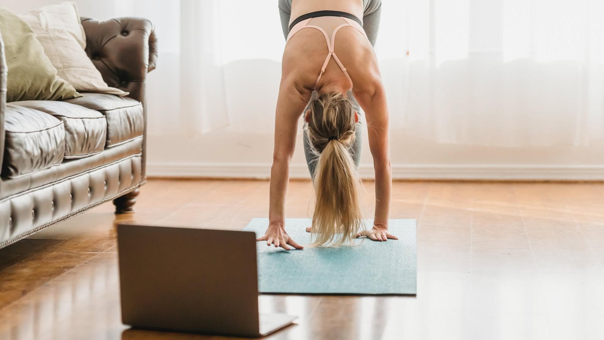 Frau macht Online Fitnesskurse auf einer Sportmatte