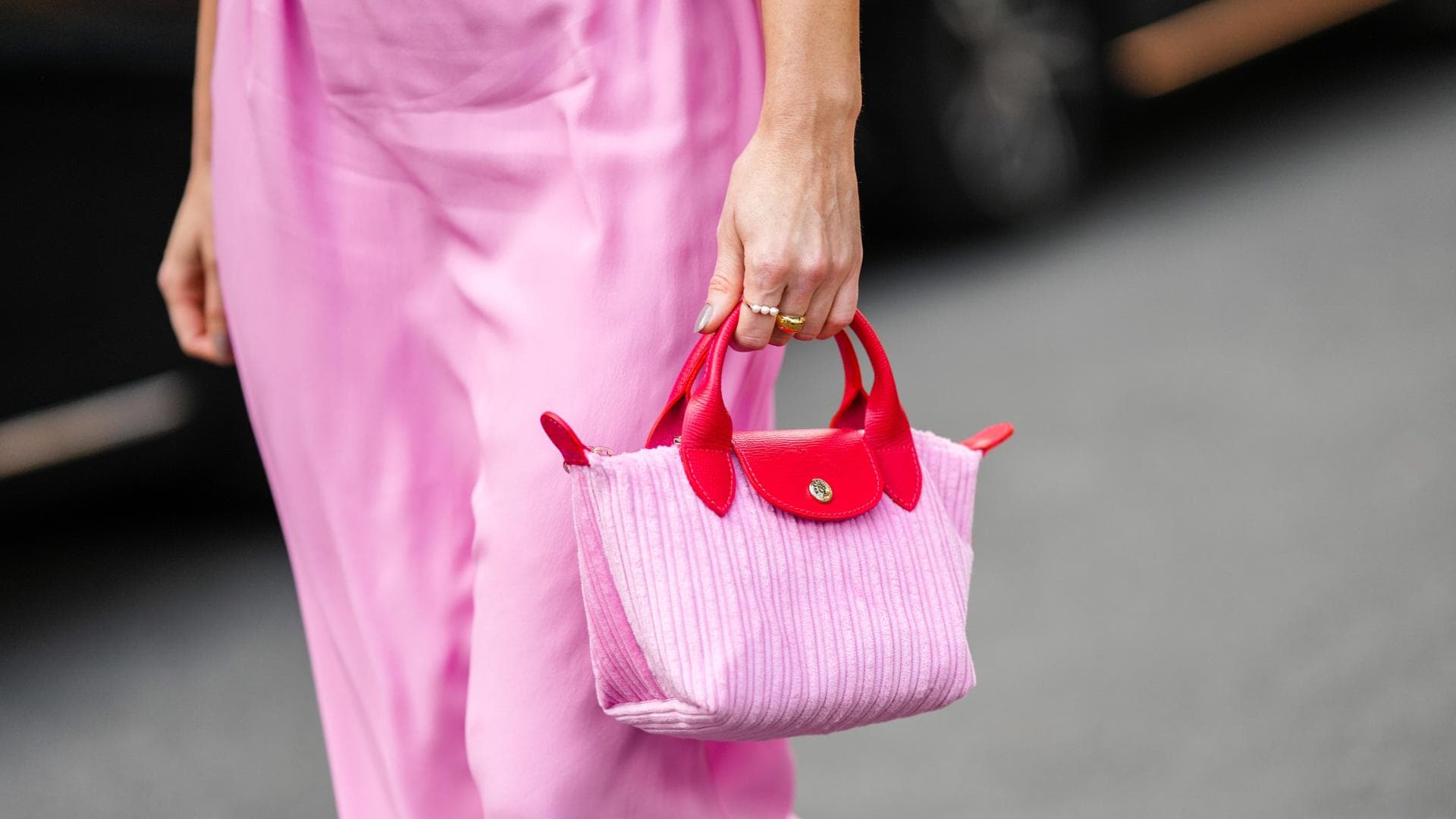 Frau trägt pinke Longchamp-Tasche im Streetstyle