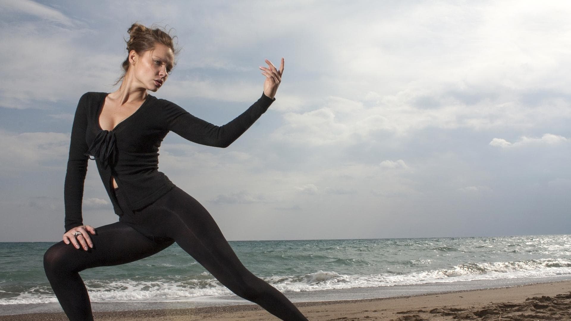 Frau macht Yoga am Strand
