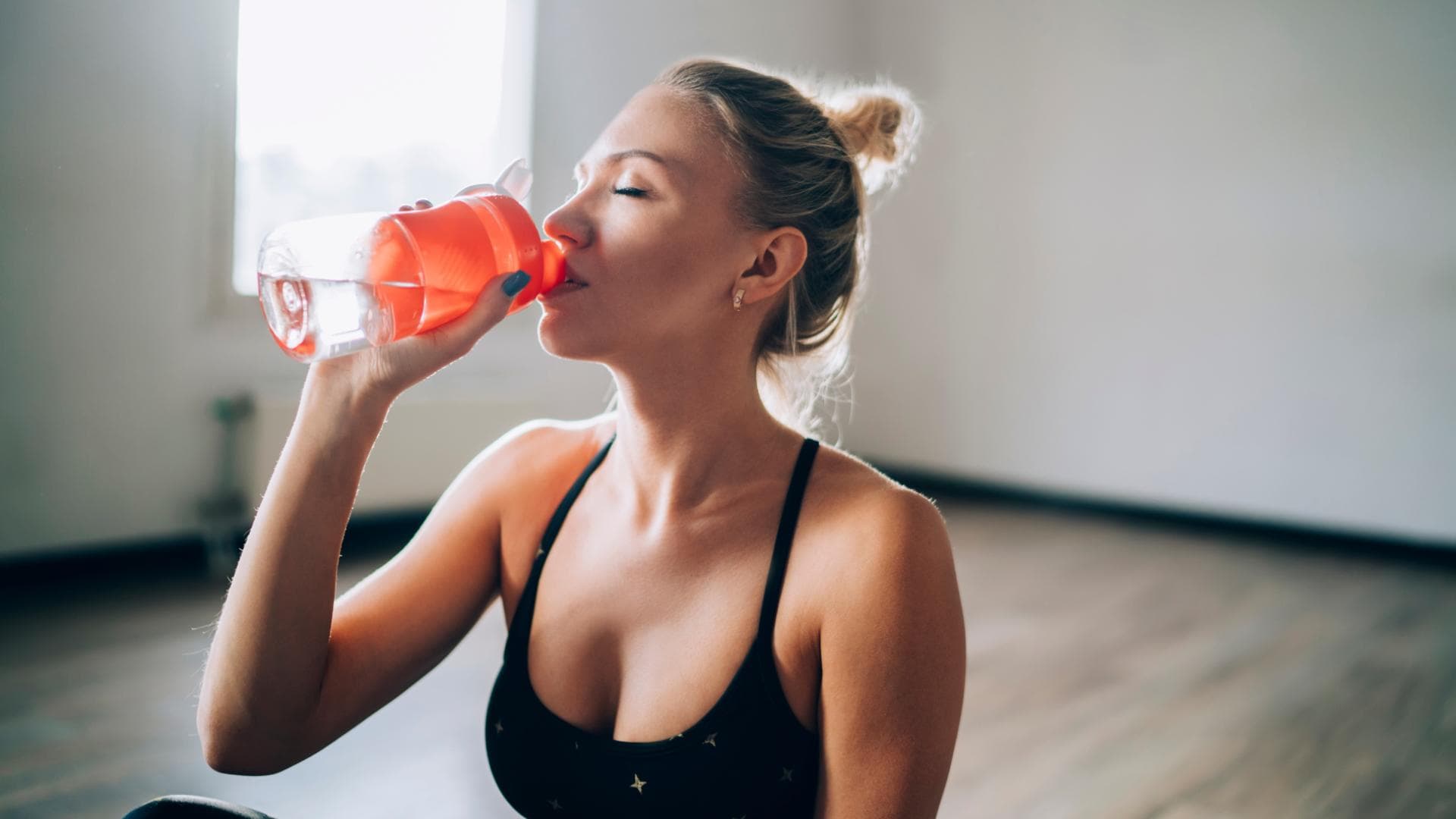 Frau trinkt aus einer Wasserflasche