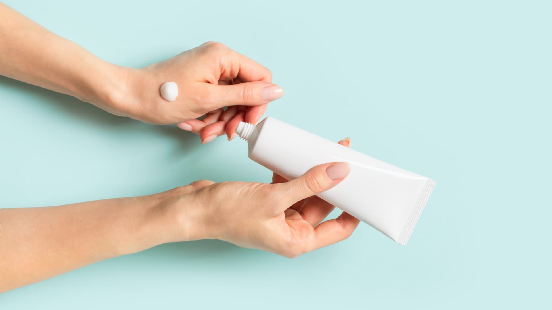 Frau cremt sich die Hände ein