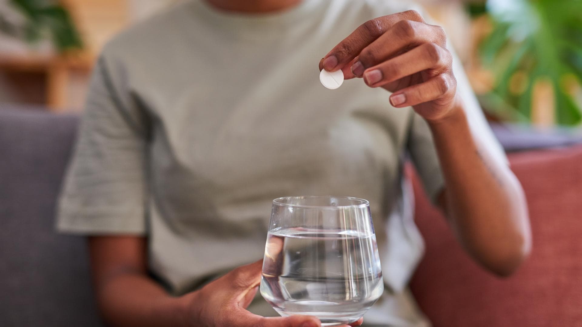 Frau wirft Brausetablette in ein Glas Wasser