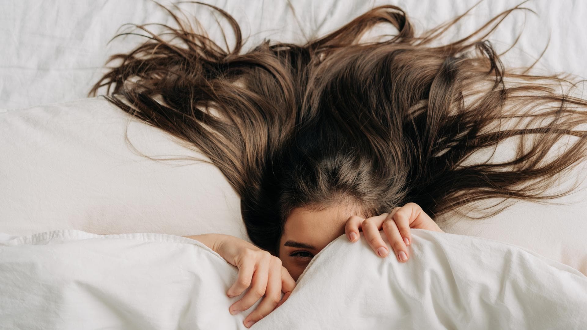 Frau mit langen Haaren im Bett