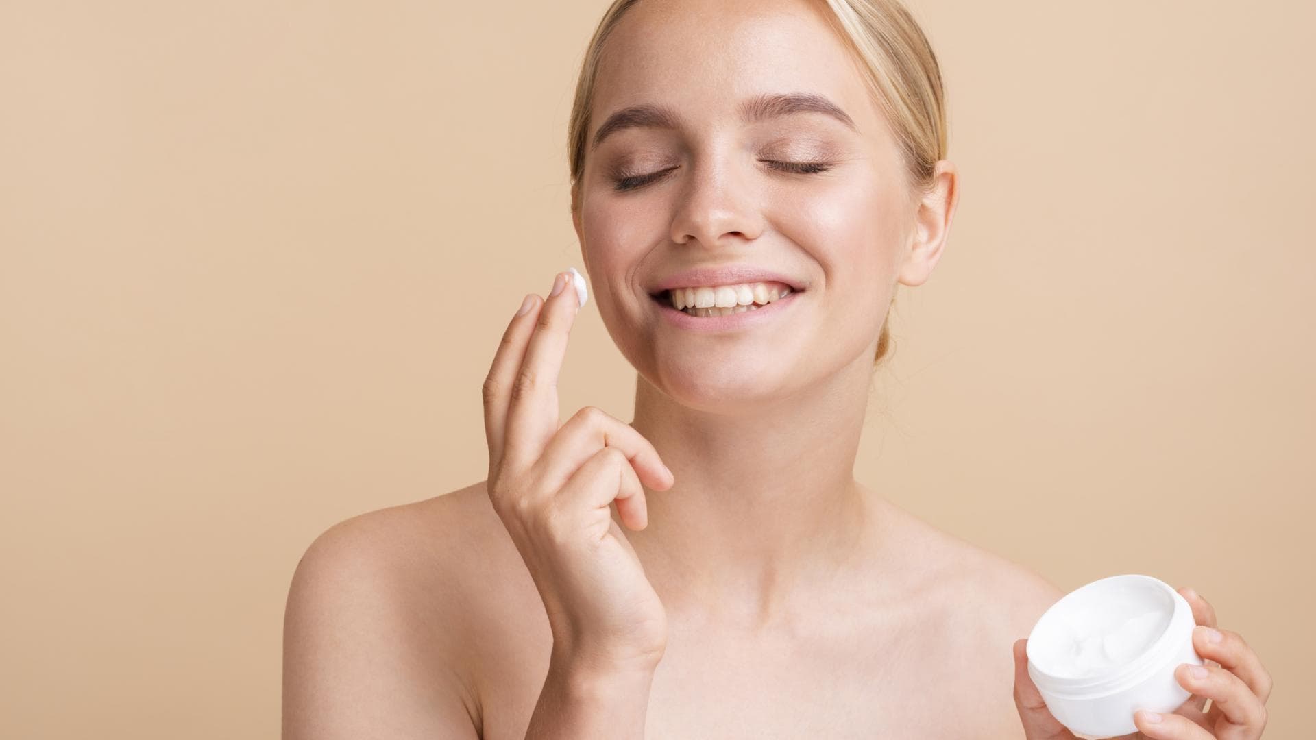 Frau cremt Gesicht ein