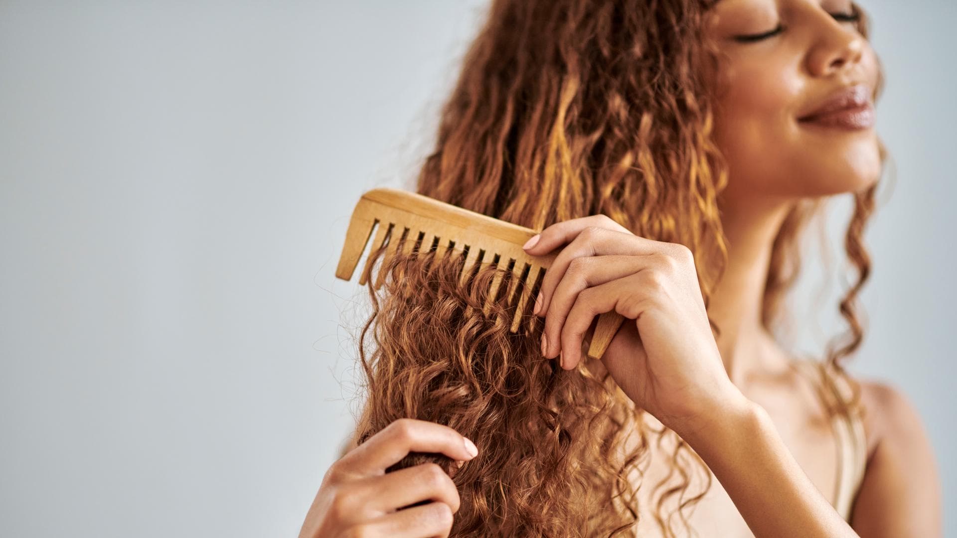 Frau kämmt lockige Haare