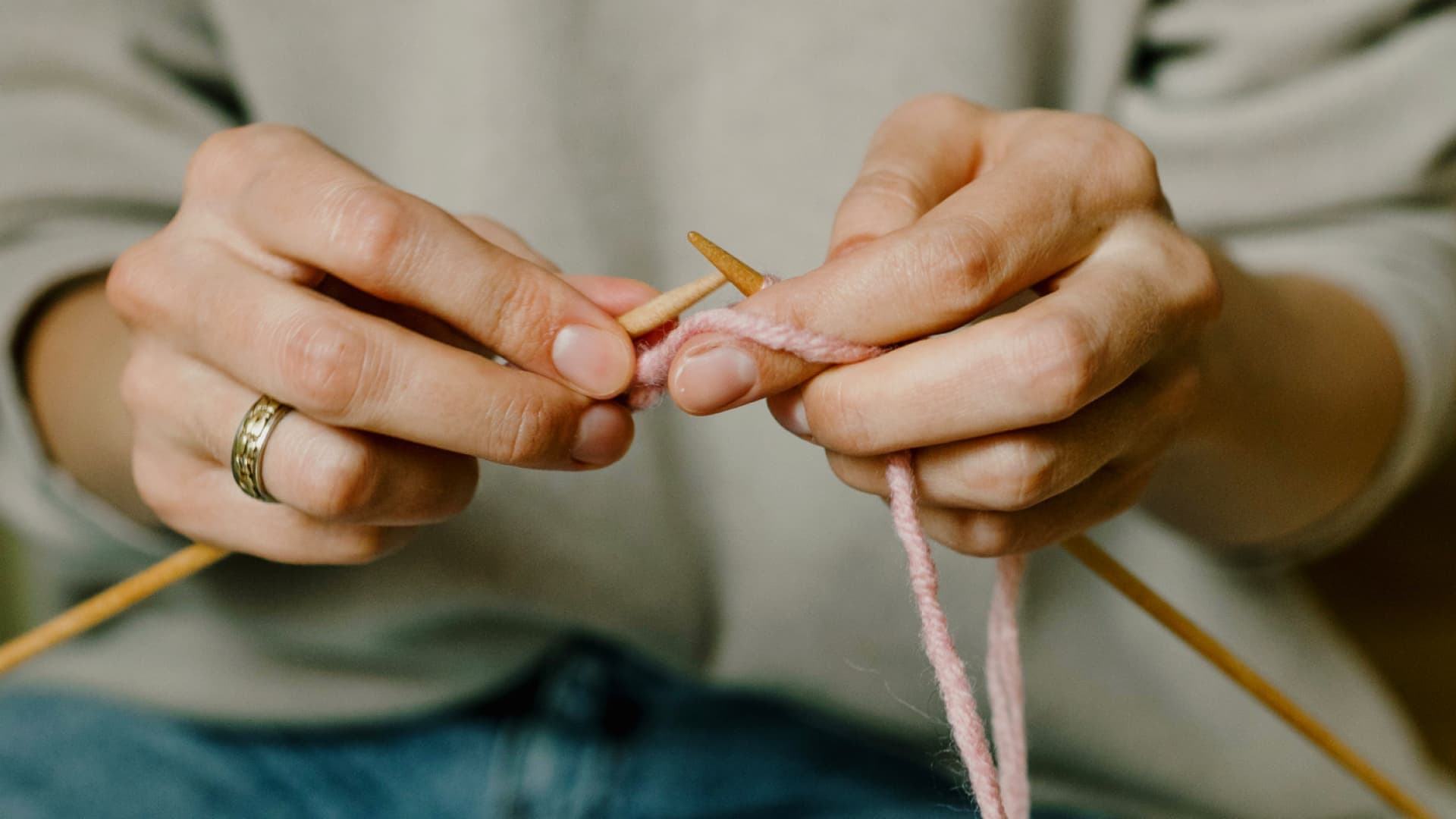 Frau lernt Maschen aufzunehmen, um Stricken zu lernen
