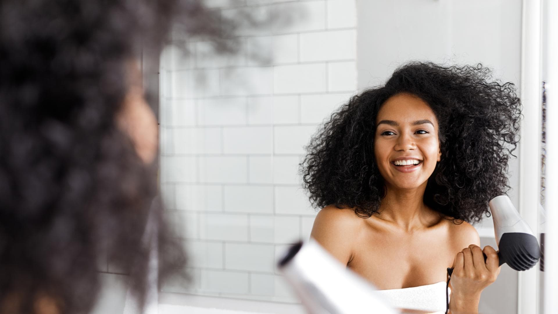 Frau föhnt Locken