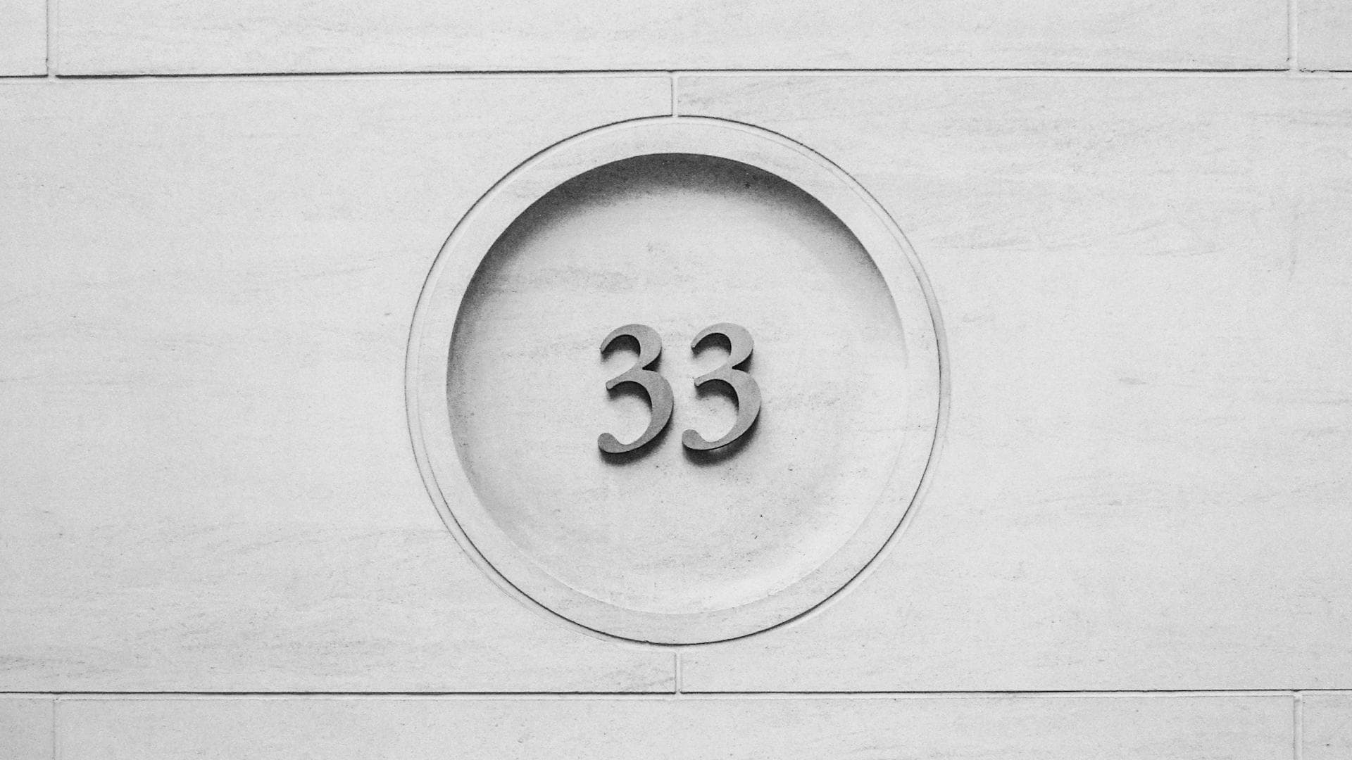 Die Zahl 33 an einer Wand in einem Kreis