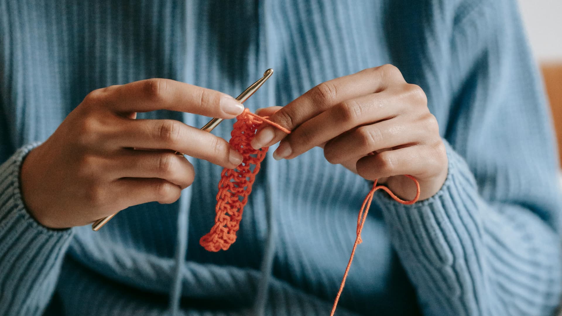 Frau häkelt etwas mit Wolle