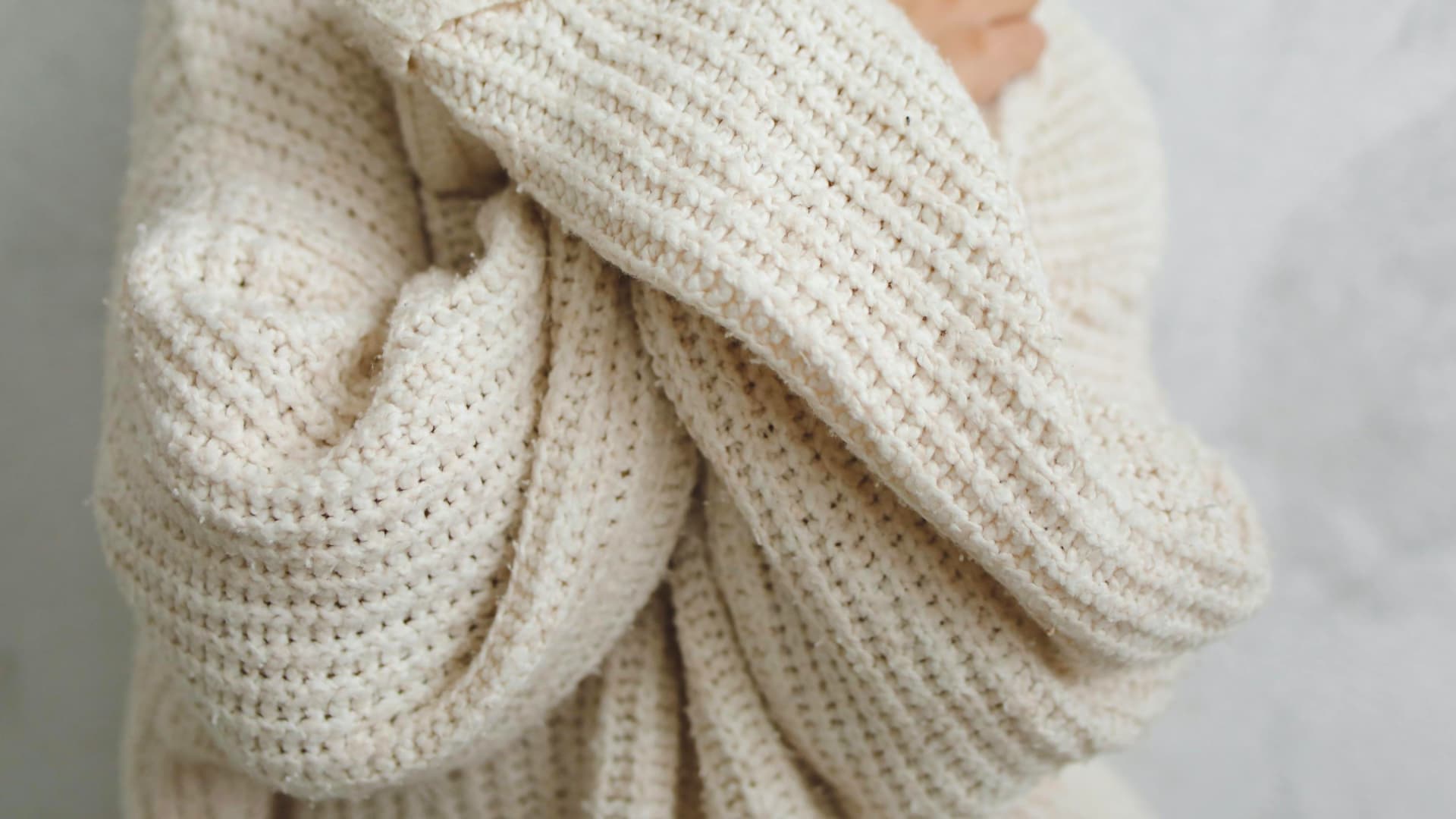 Eine Frau trägt einen selbst gestrickten Pullover aus warmer Wolle