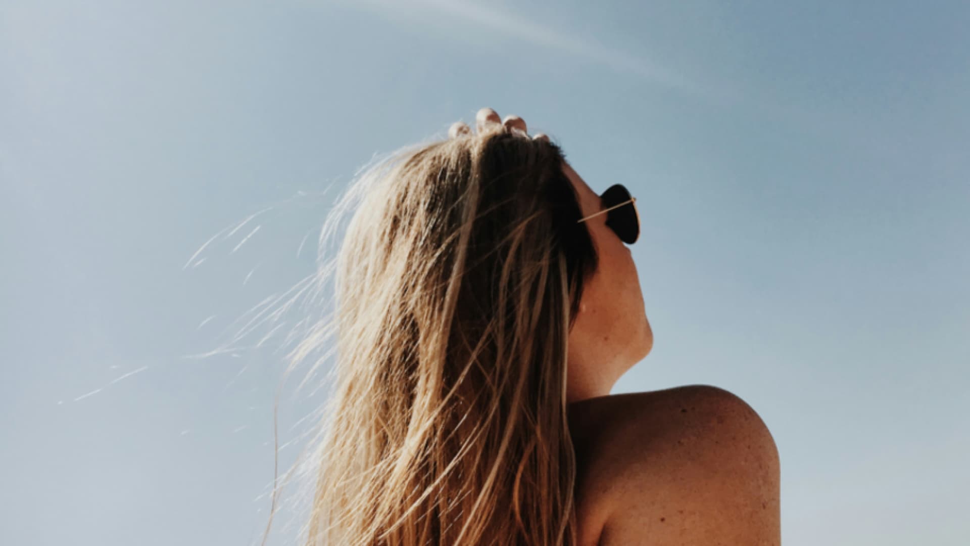 Eine Frau mit Sonnenbrille in der Sonne