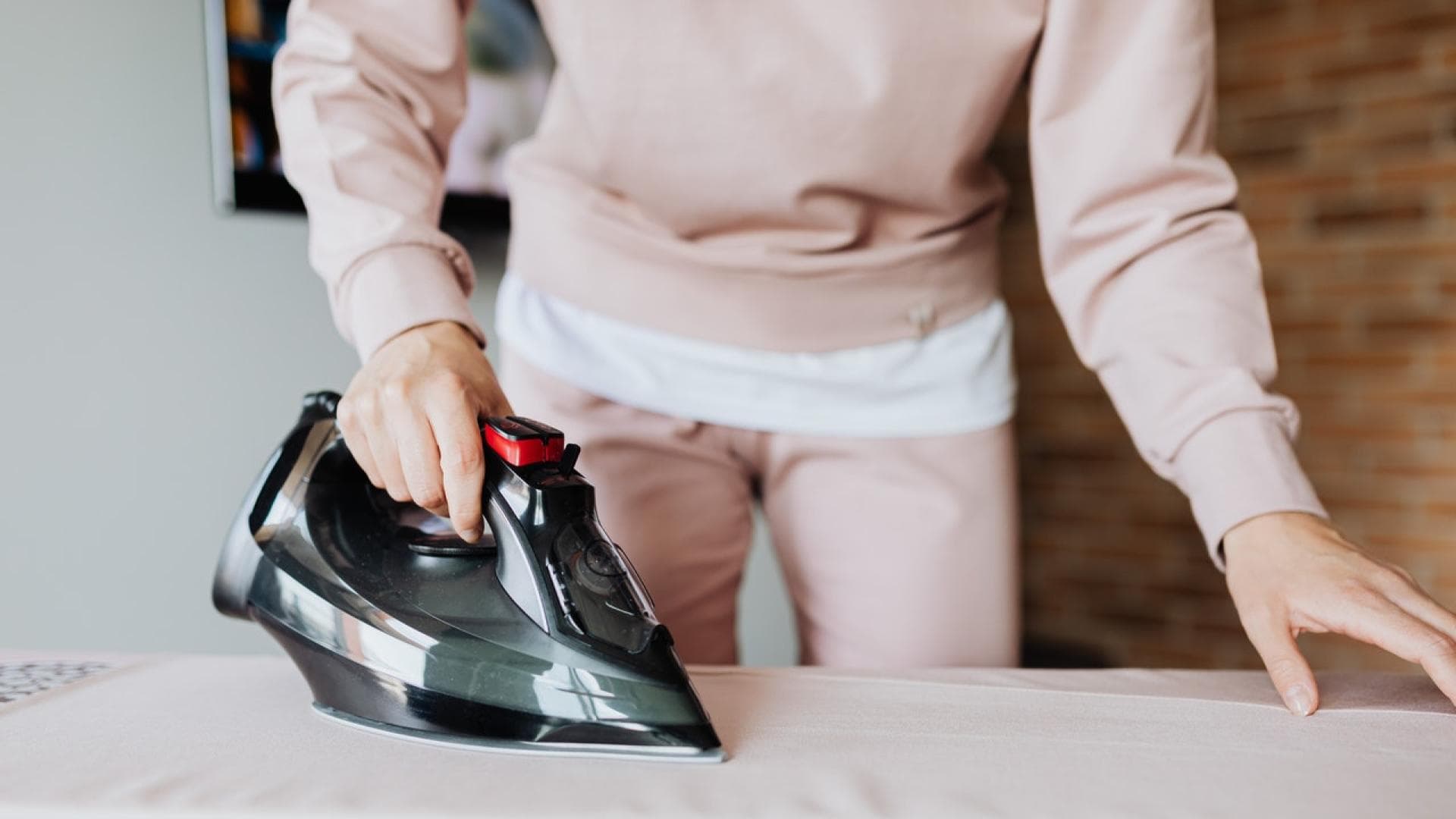 Frau bügelt mit entkalktem Bügeleisen