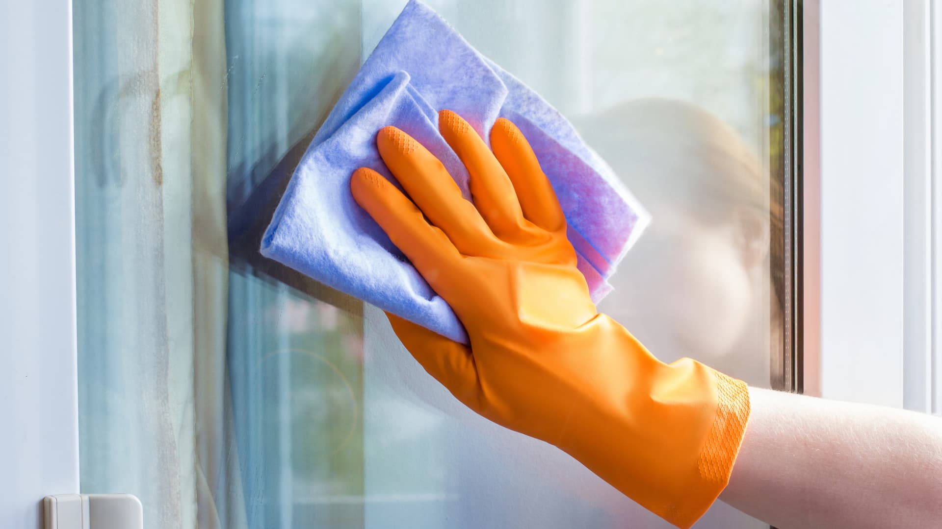 Frau putzt Fenster