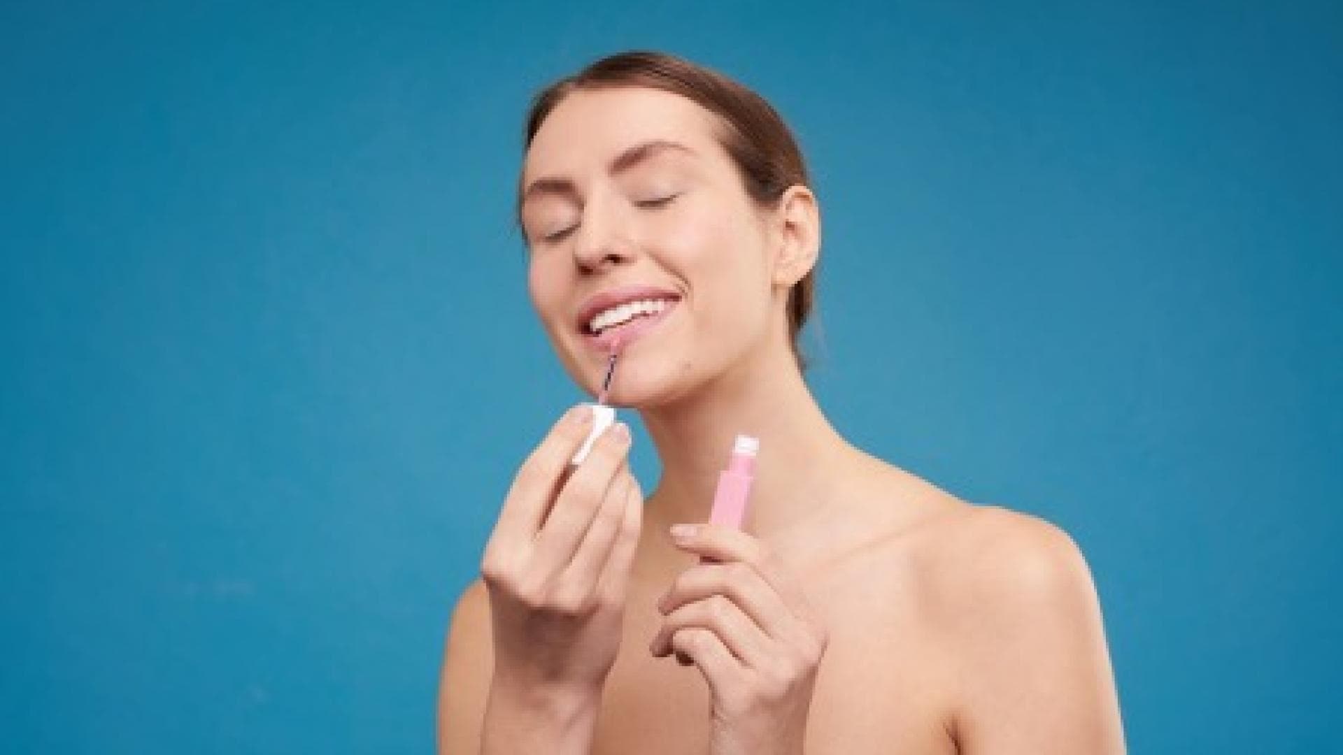 Frau trägt ein Lippenprodukt auf
