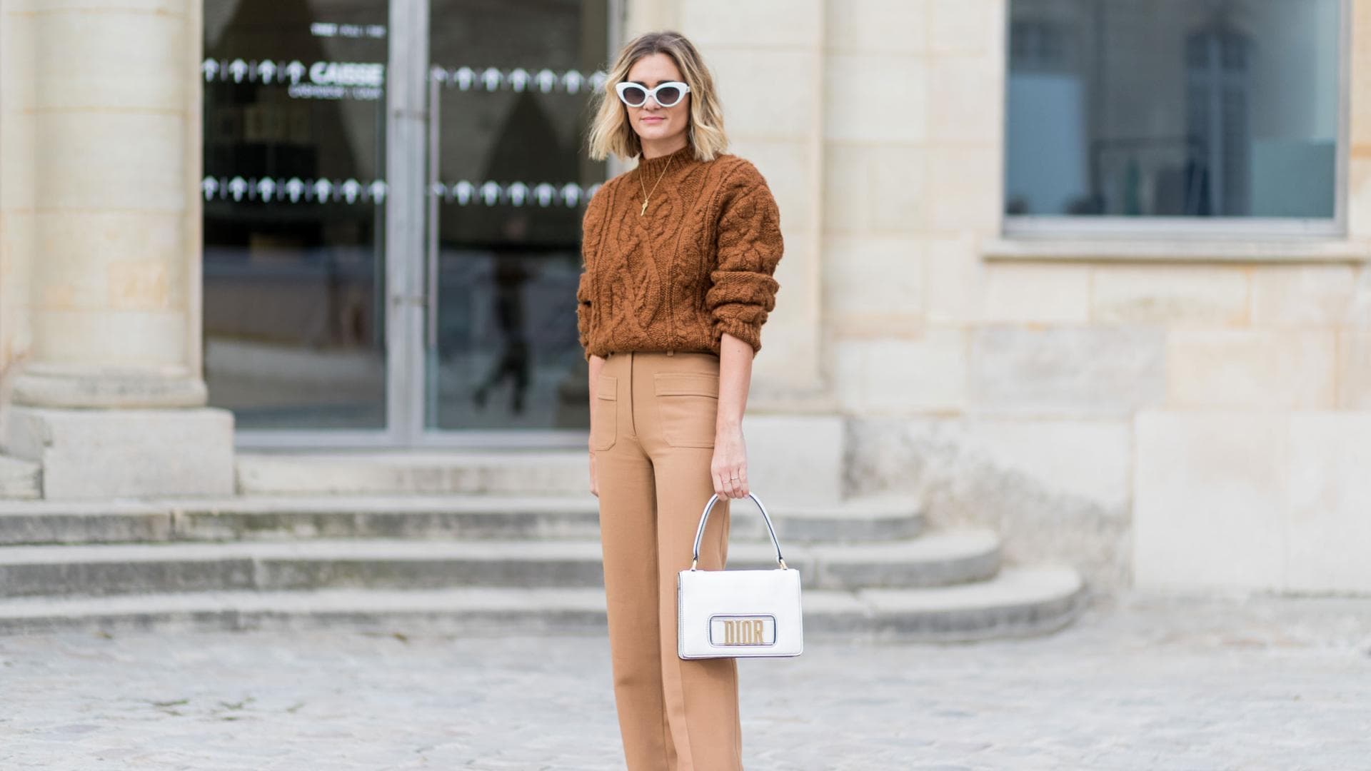 Eine Frau trägt einen Pullover mit Zopfstrickmuster