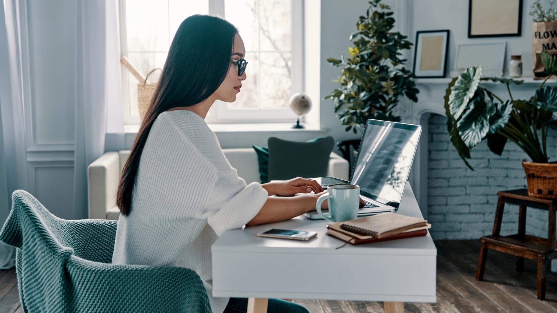 Eine Frau sitzt am Laptop und arbeitet