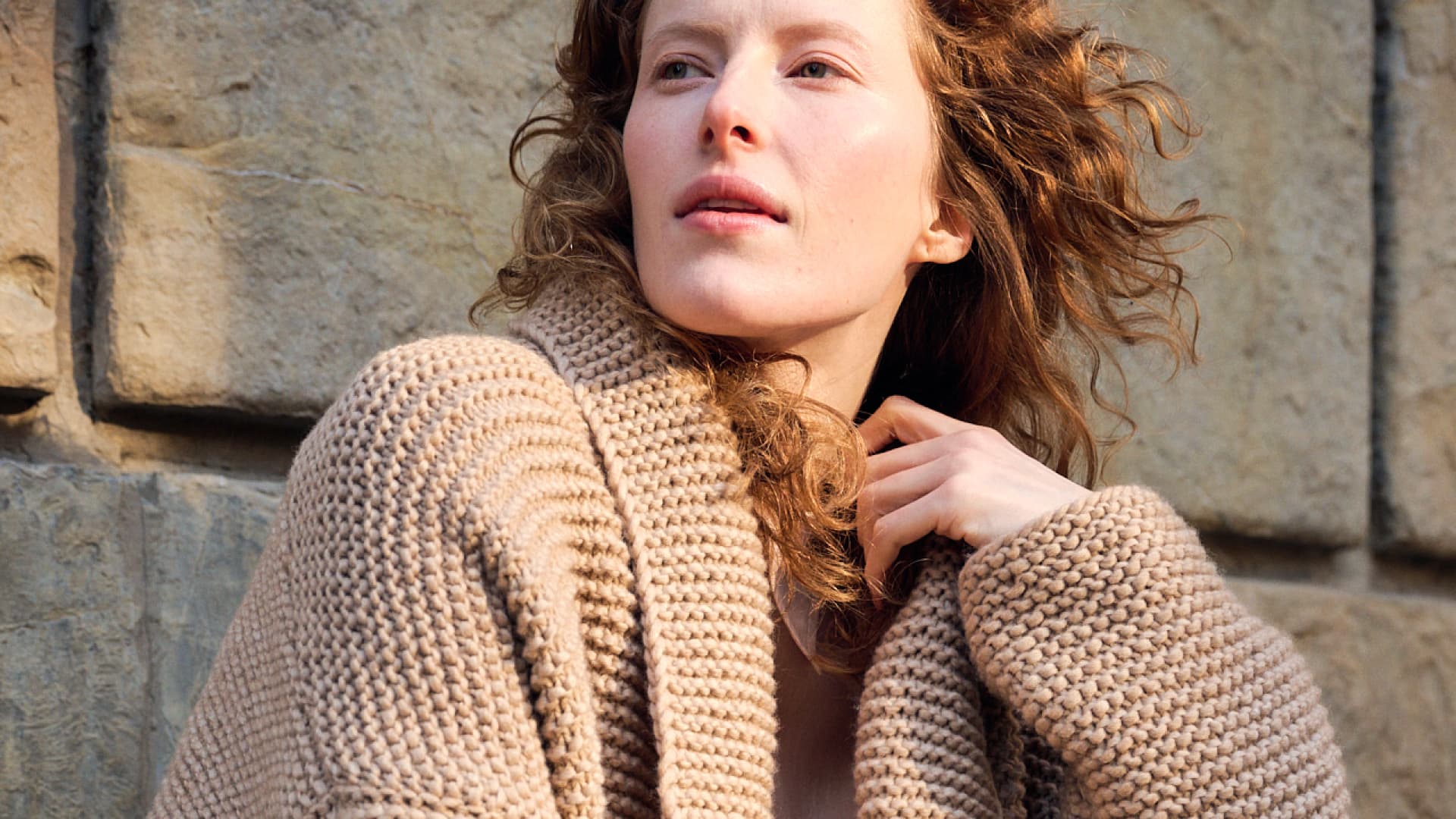 Model mit beiger Strickjacke mit Schalkragen von Lana Grossa