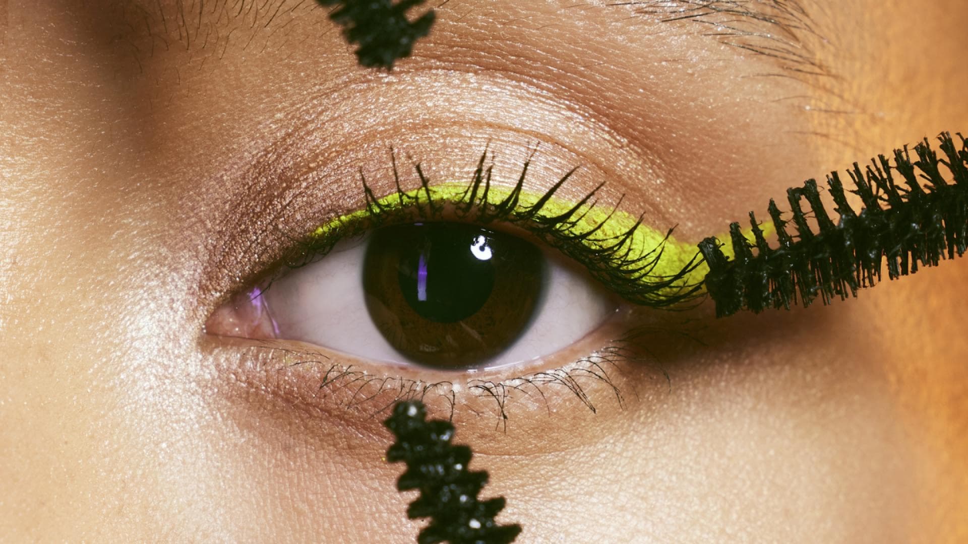 Braunes Auge mit neon-lidstrich und mehreren wimpern-bürsten