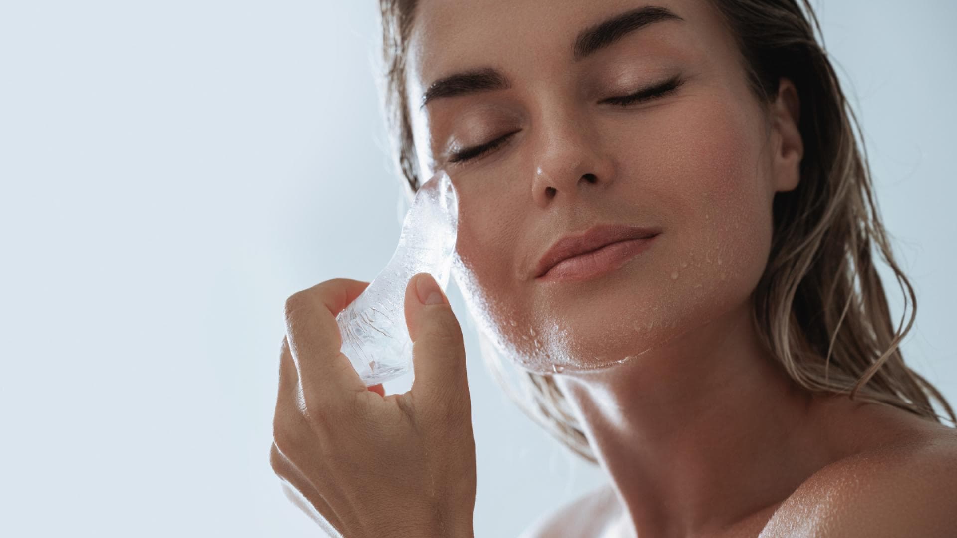 schöne Frau mit Eis am Gesicht