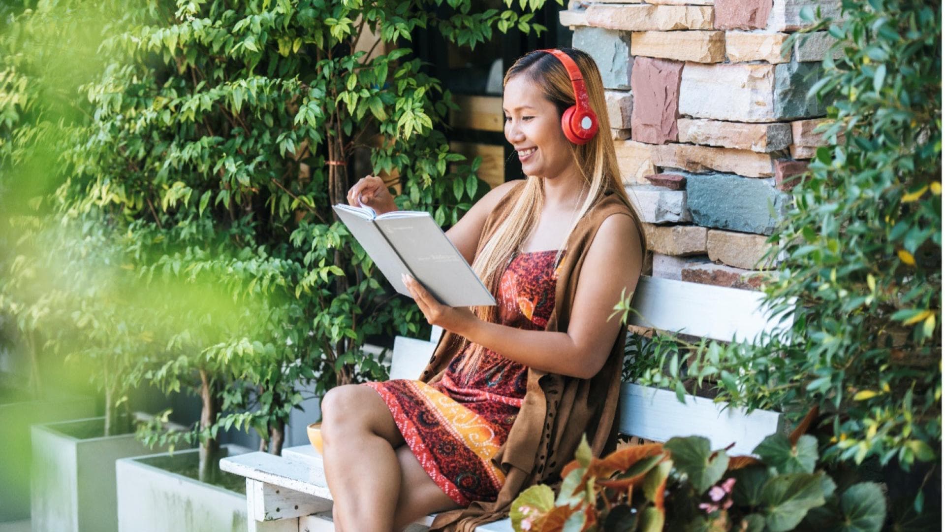 Eine Frau liest ein Buch im Garten