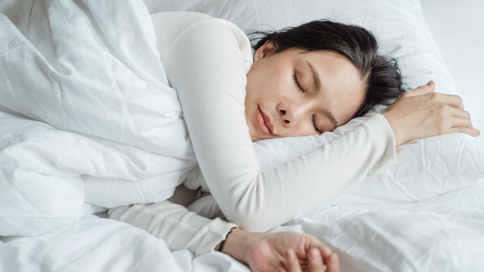 Eine Frau schläft in ihrem Bett