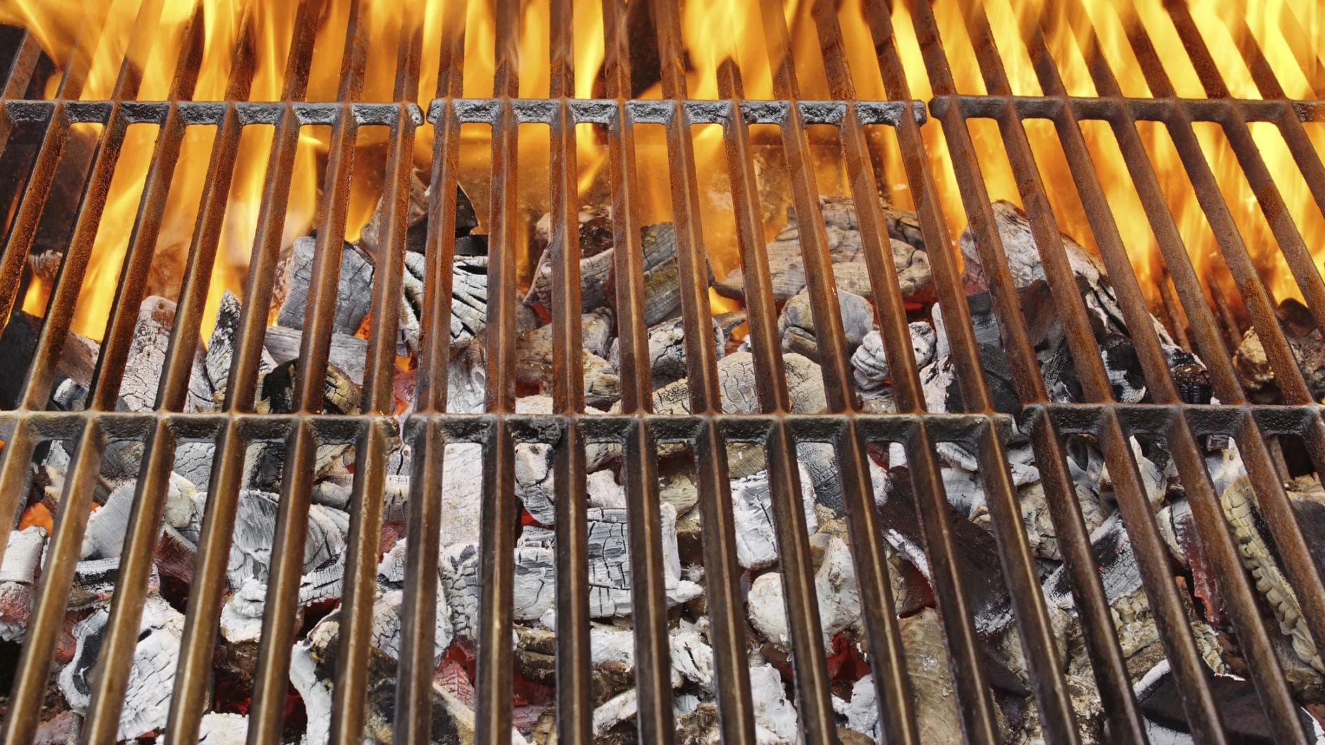 Grillrost mit Feuer - Wir geben Tipps, wie Sie Ihren Grill wieder sauber bekommen – mit wenig Aufwand und Geld