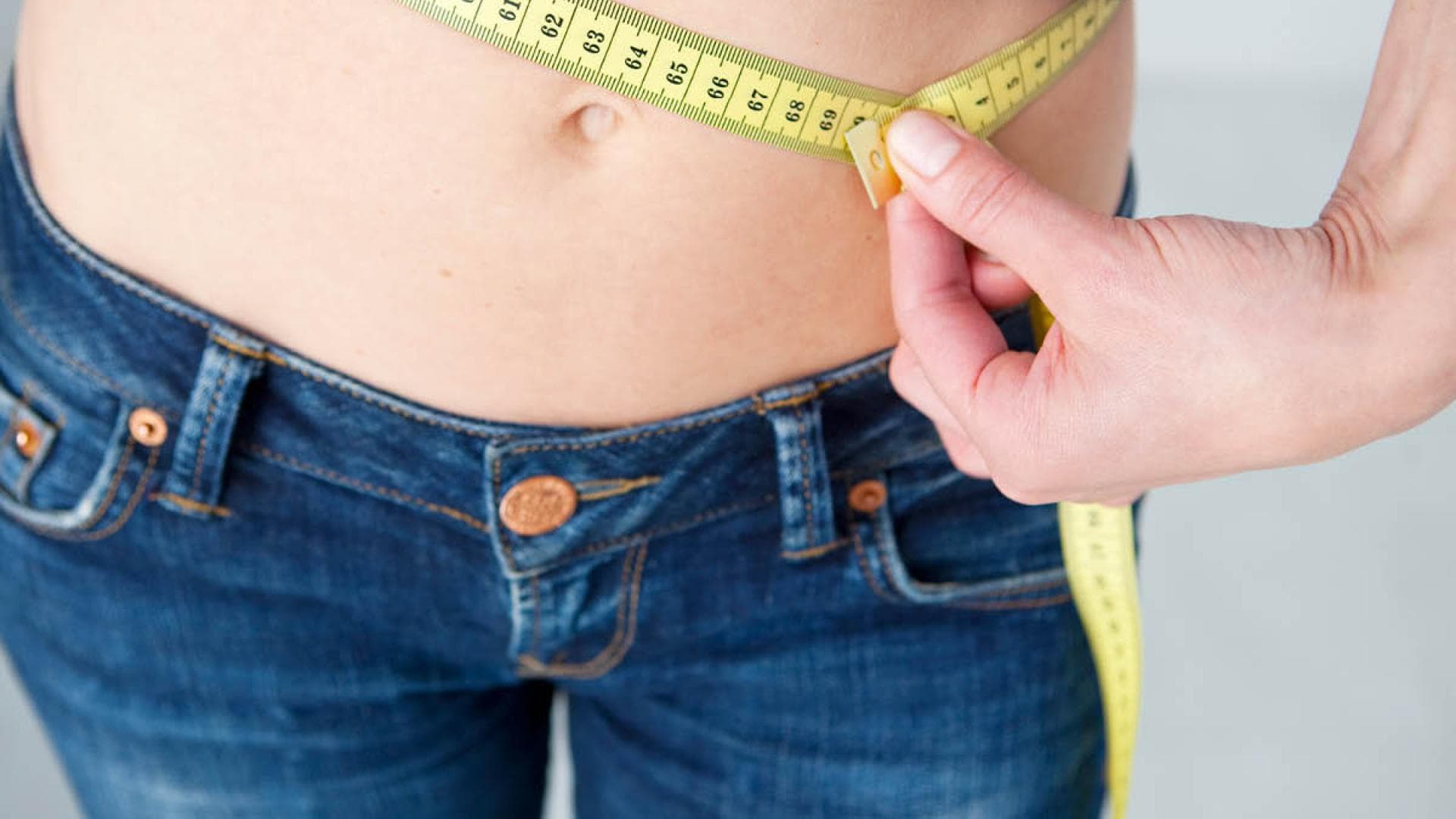 Frau in Blau misst Taillenumfang