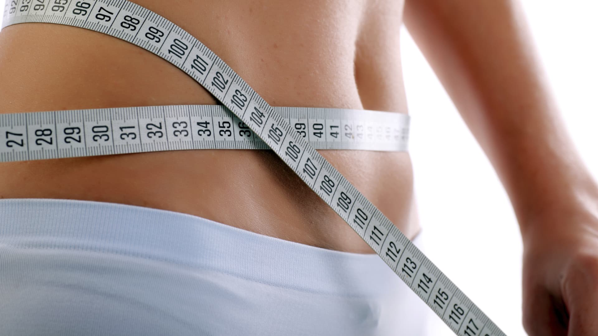 Frau mit Maßband um den Bauch