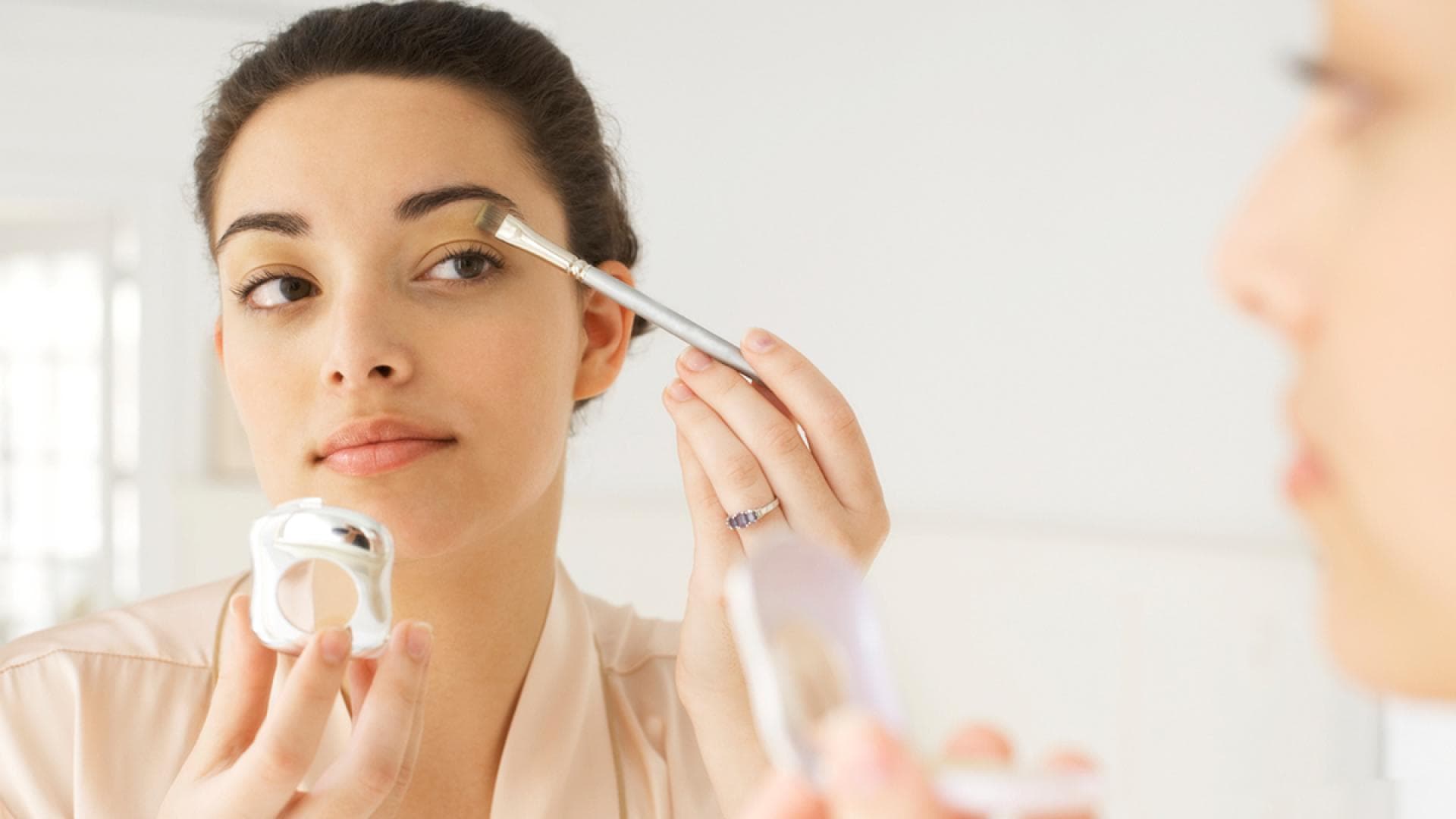 Frau schminkt sich die Augen - Wir geben Tipps für das perfekte Make-up für Rehaugen und Schneewittchen