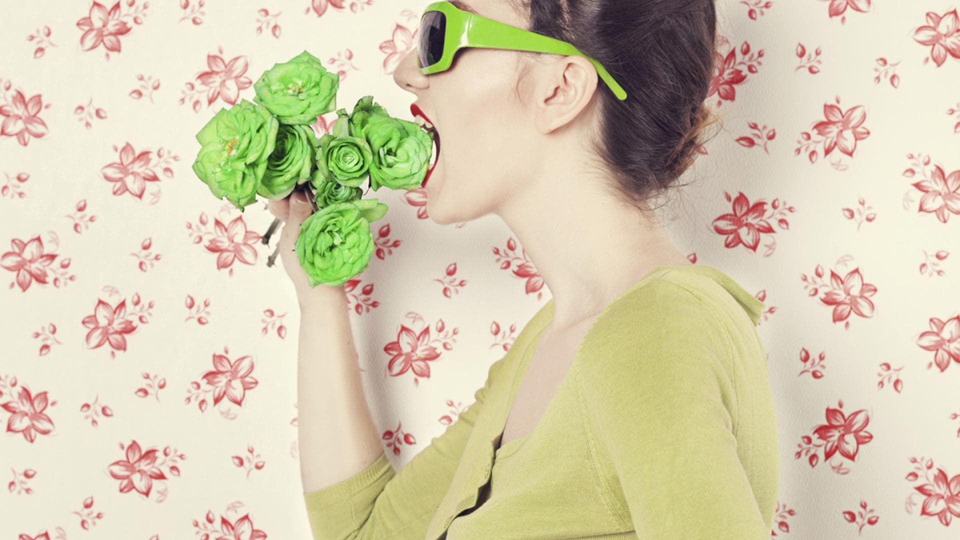 Frau beißt in grüne Blumen