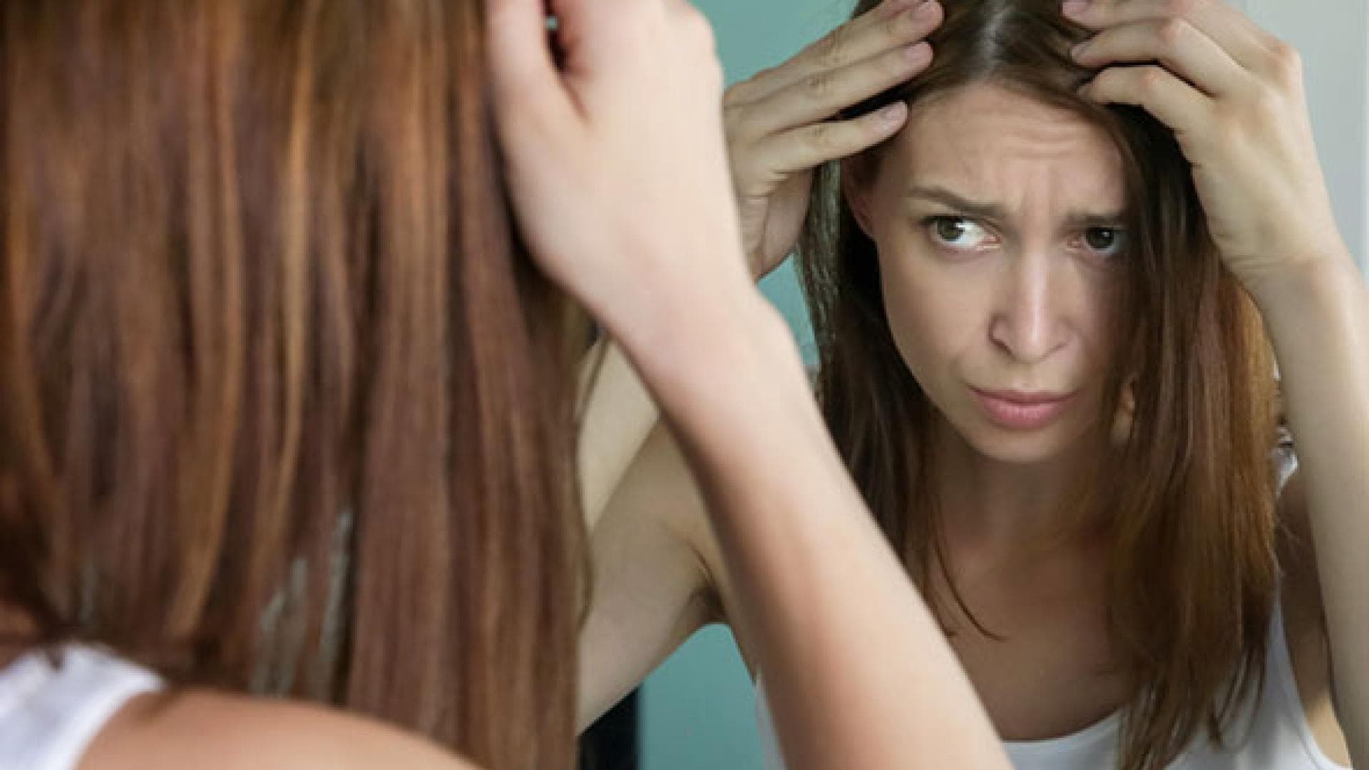 Frau prüft graue Haare – graue Haare durch Stress