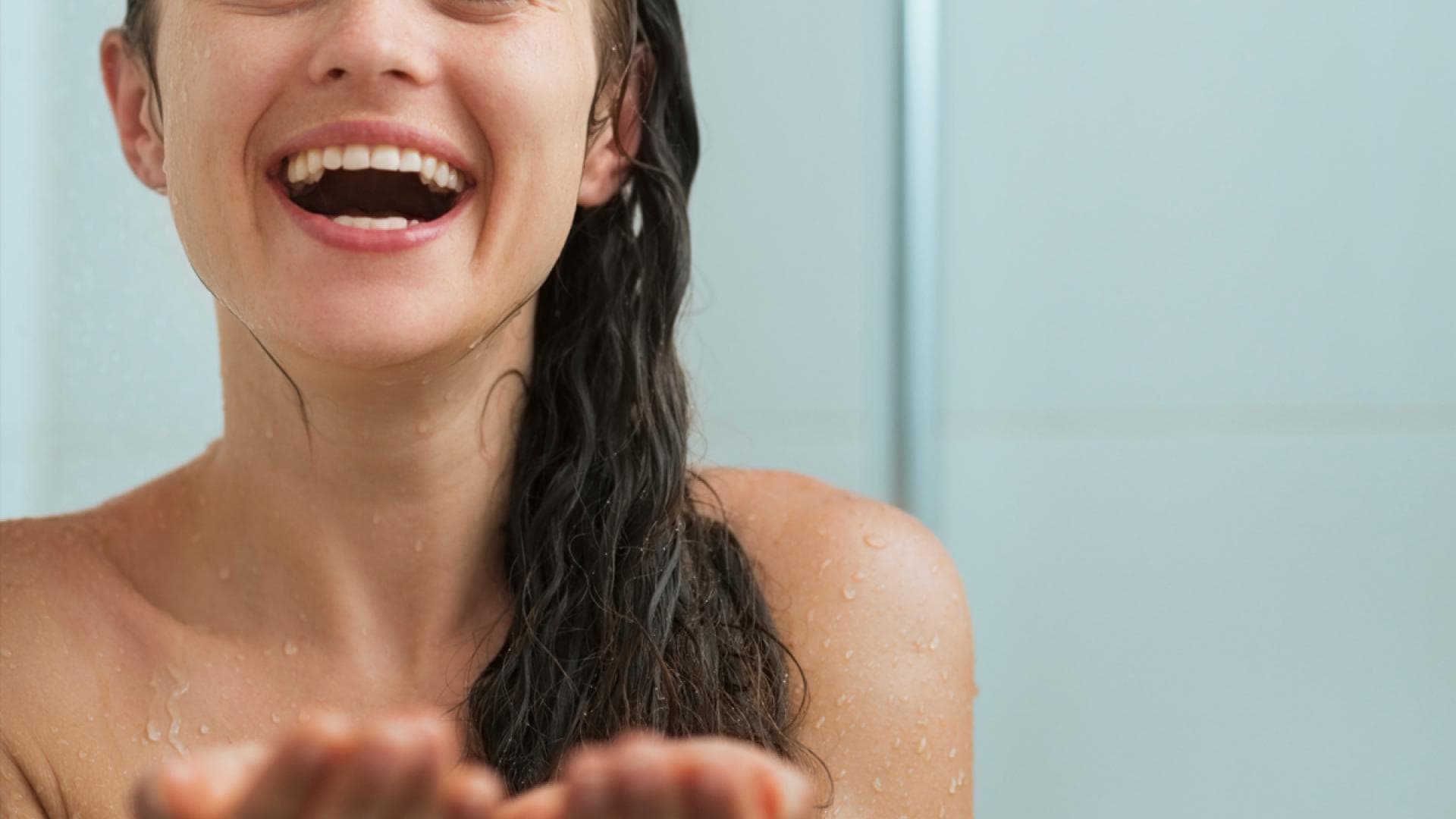 Lachende Frau in der Dusche - Tipps für eine bessere Durchblutung 