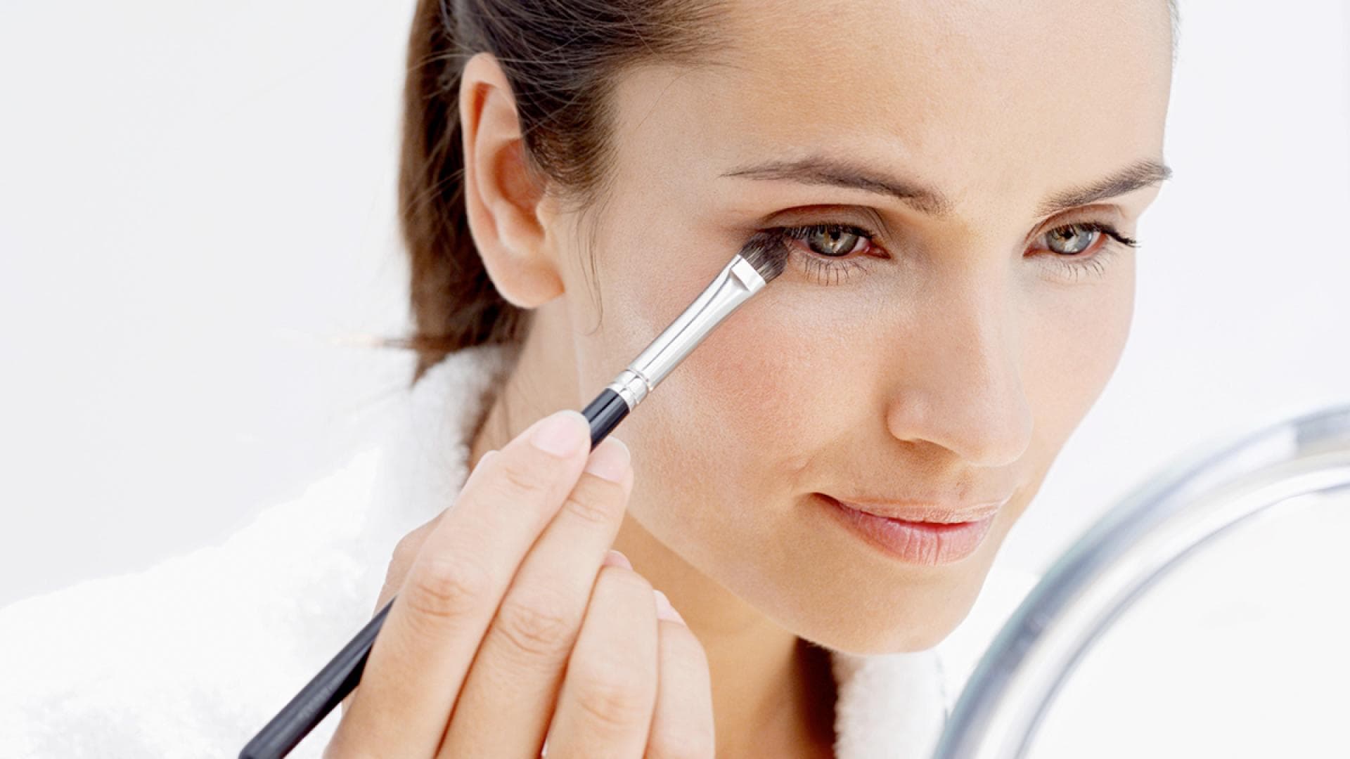 Frau schminkt sich die grünen Augen - Das perfekte Make-Up für grüne Augen 