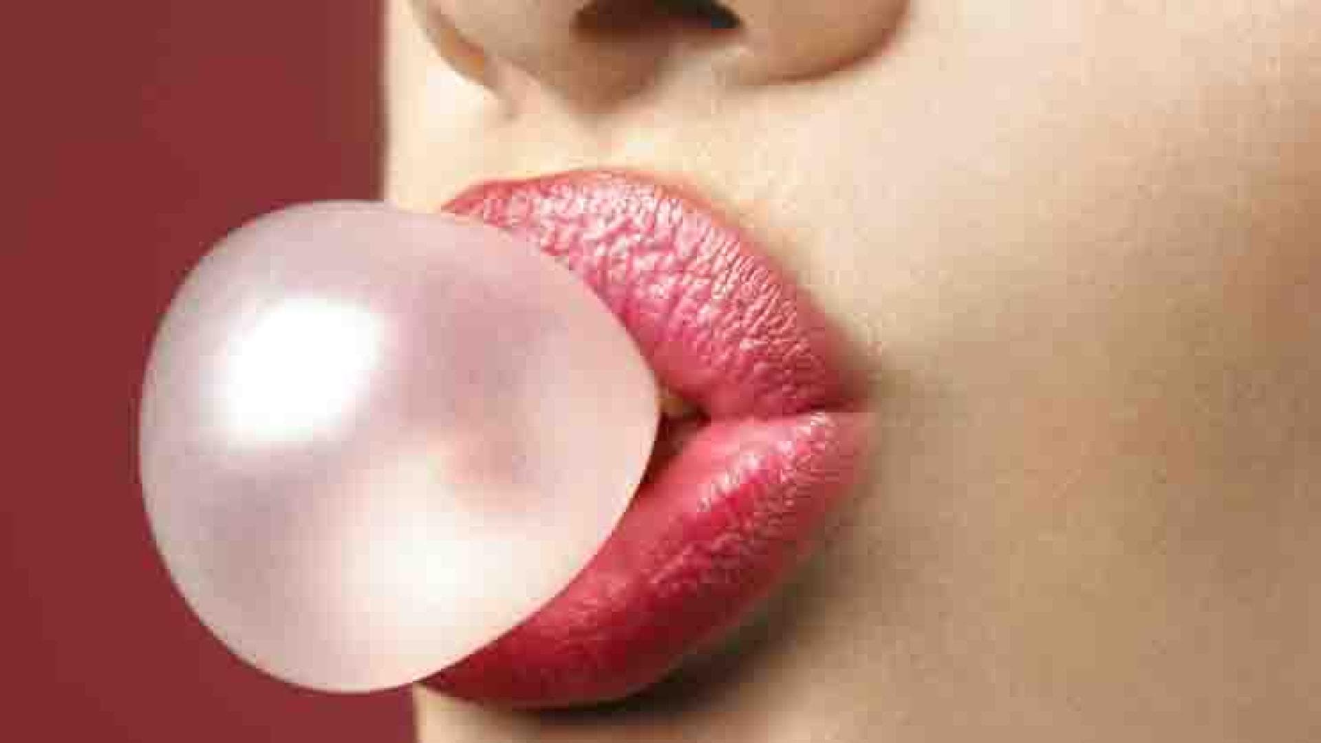 Frau kaut Kaugummi und macht eine Kaugummi-Blase - Hat Kaugummi auch eine positive Auswirkung auf unsereGesundheit?