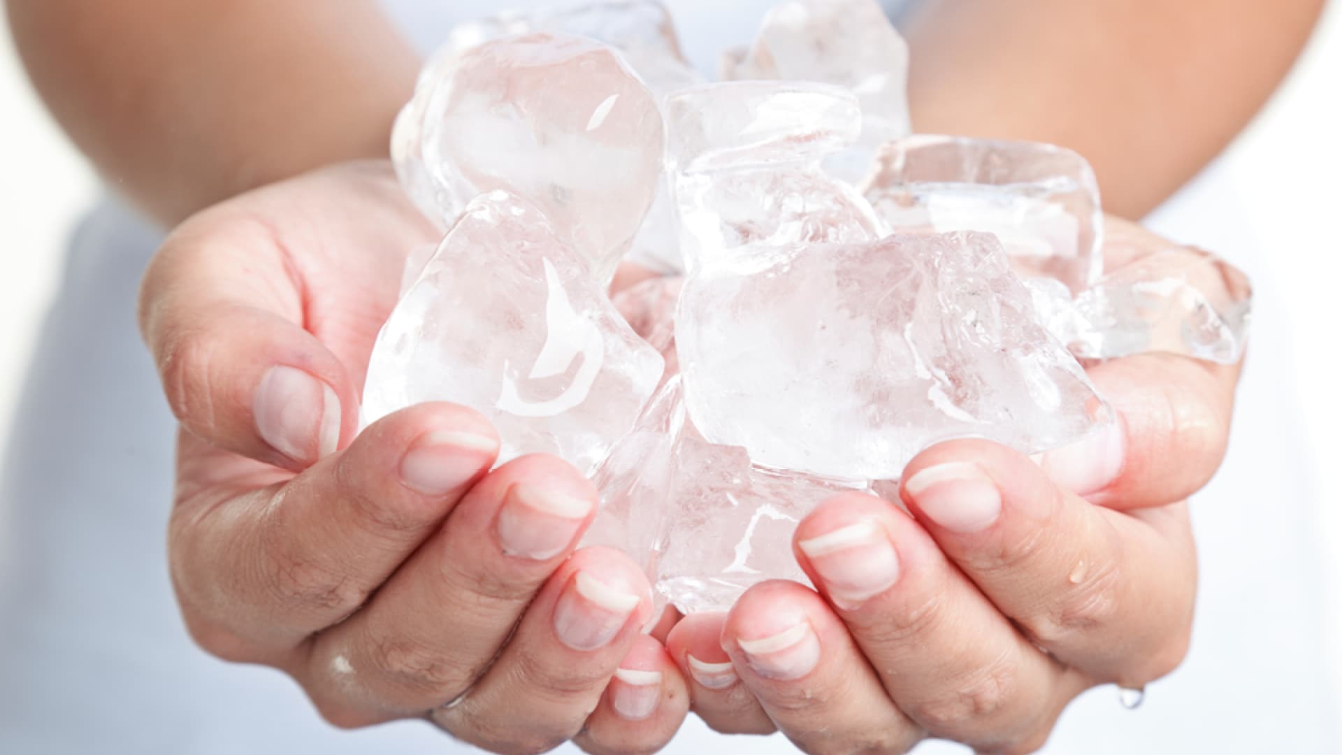 Frau hält Eiswürfel