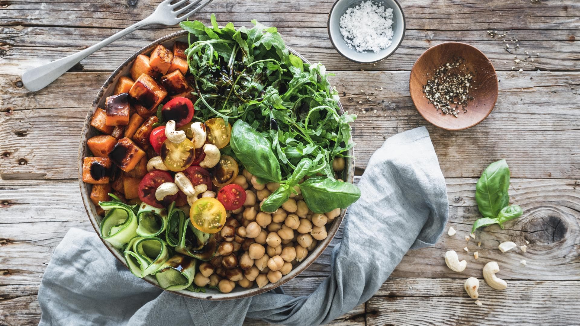 Salat-Bowl mit gerösteten Süßkartoffeln, Rucola und bunten Tomaten