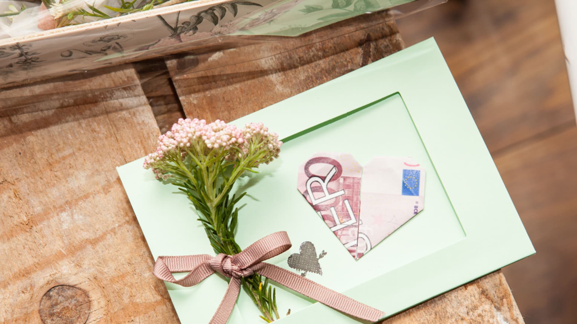 Passepartout mit gefaltetem Geldschein und Blümchen