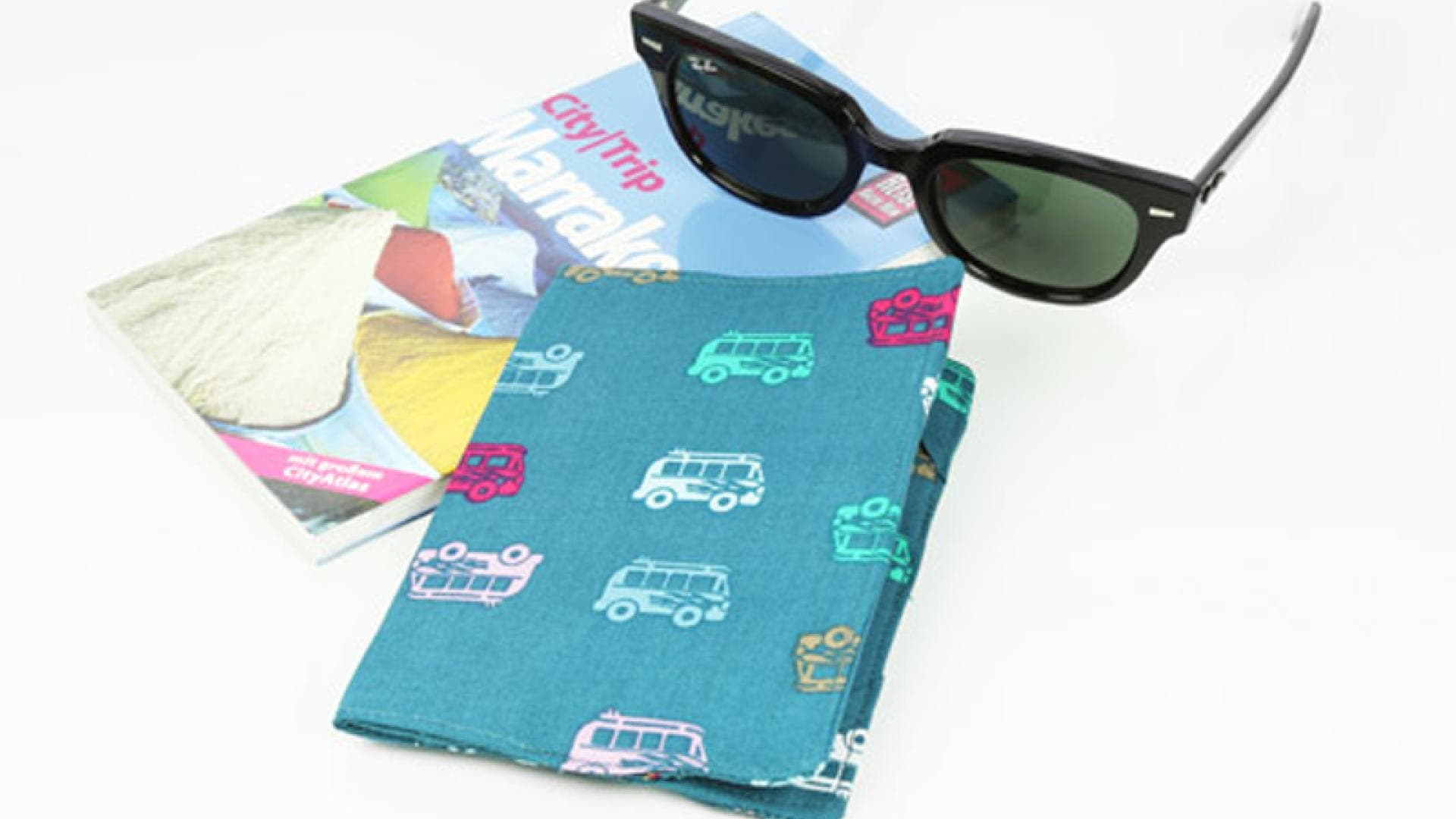 Passhülle, Sonnenbrille und Reiseführer