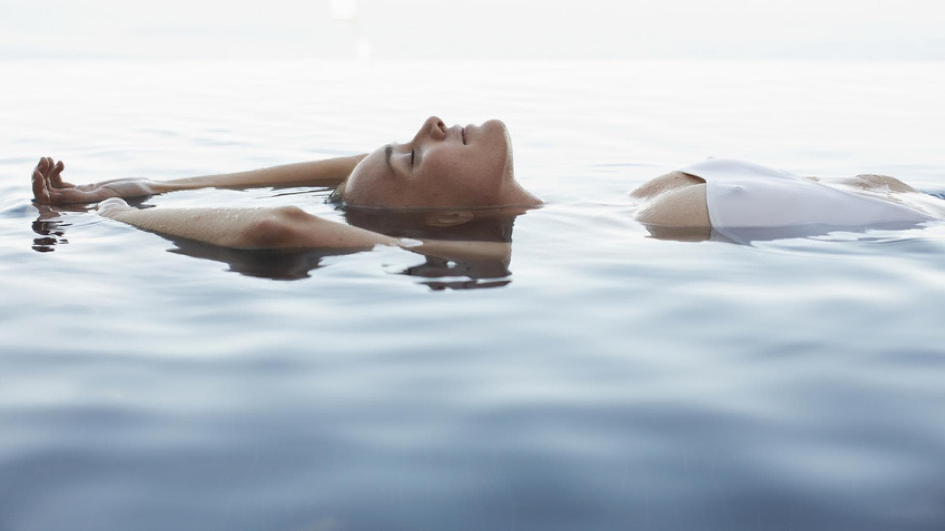 Frau liegt im Meer 